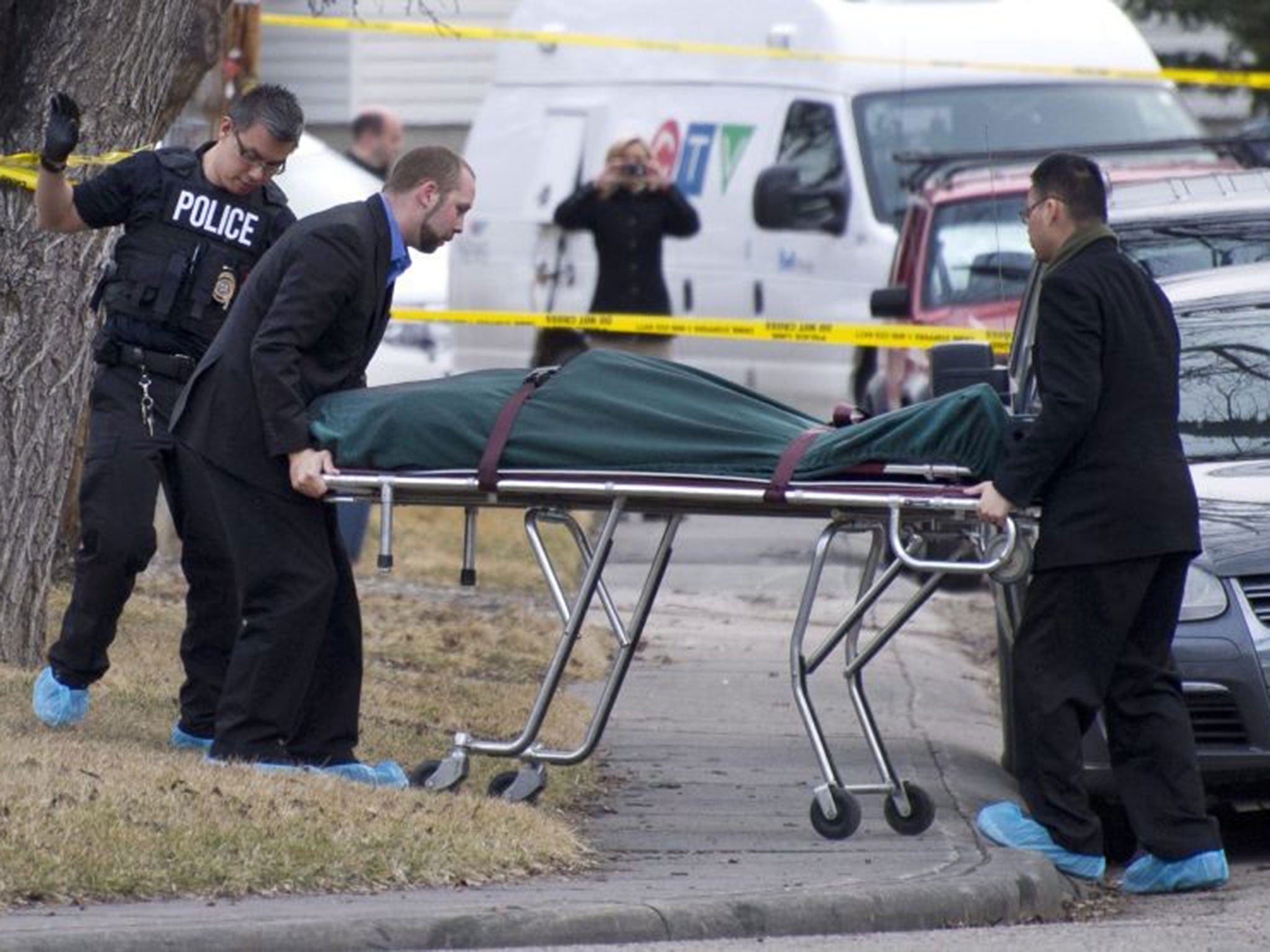 Police remove a body from the scene the stabbing in Calgary