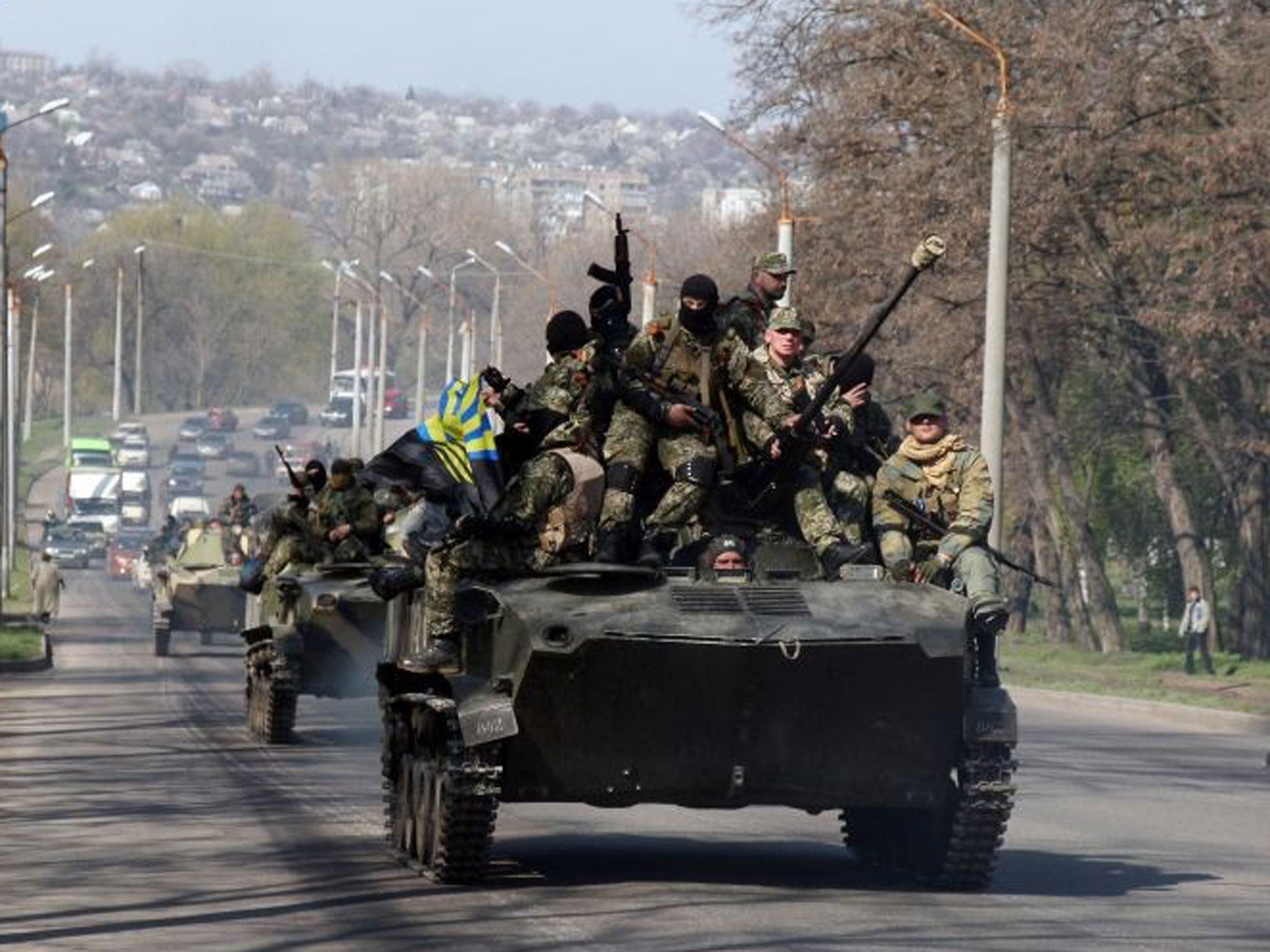 Armed people move on the few APC with Donetsk region flag in the eastern Ukrainian city of Kramatorsk on April 16, 2014.