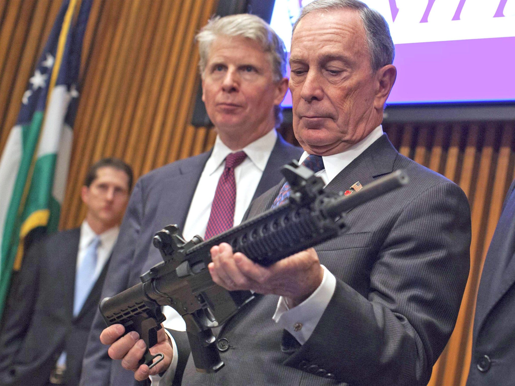 Michael Bloomberg examines a gun confiscated by police in New York during his term as the city’s mayor in 2012
