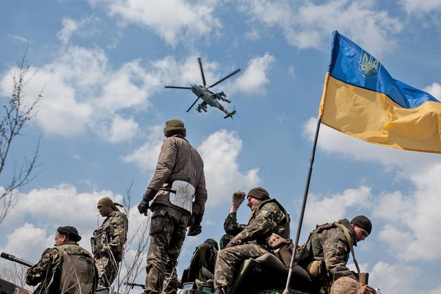 <p>Ukrainian soldiers fly the flag on top of their armoured vehicle in Kramatorsk</p>
