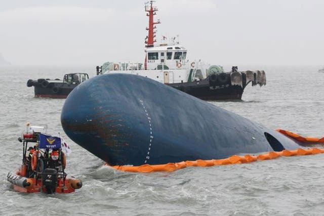 South Korean Coast Guard officers search for missing passengers aboard a sunken ferry in the water off the southern coast near Jindo, South Korea