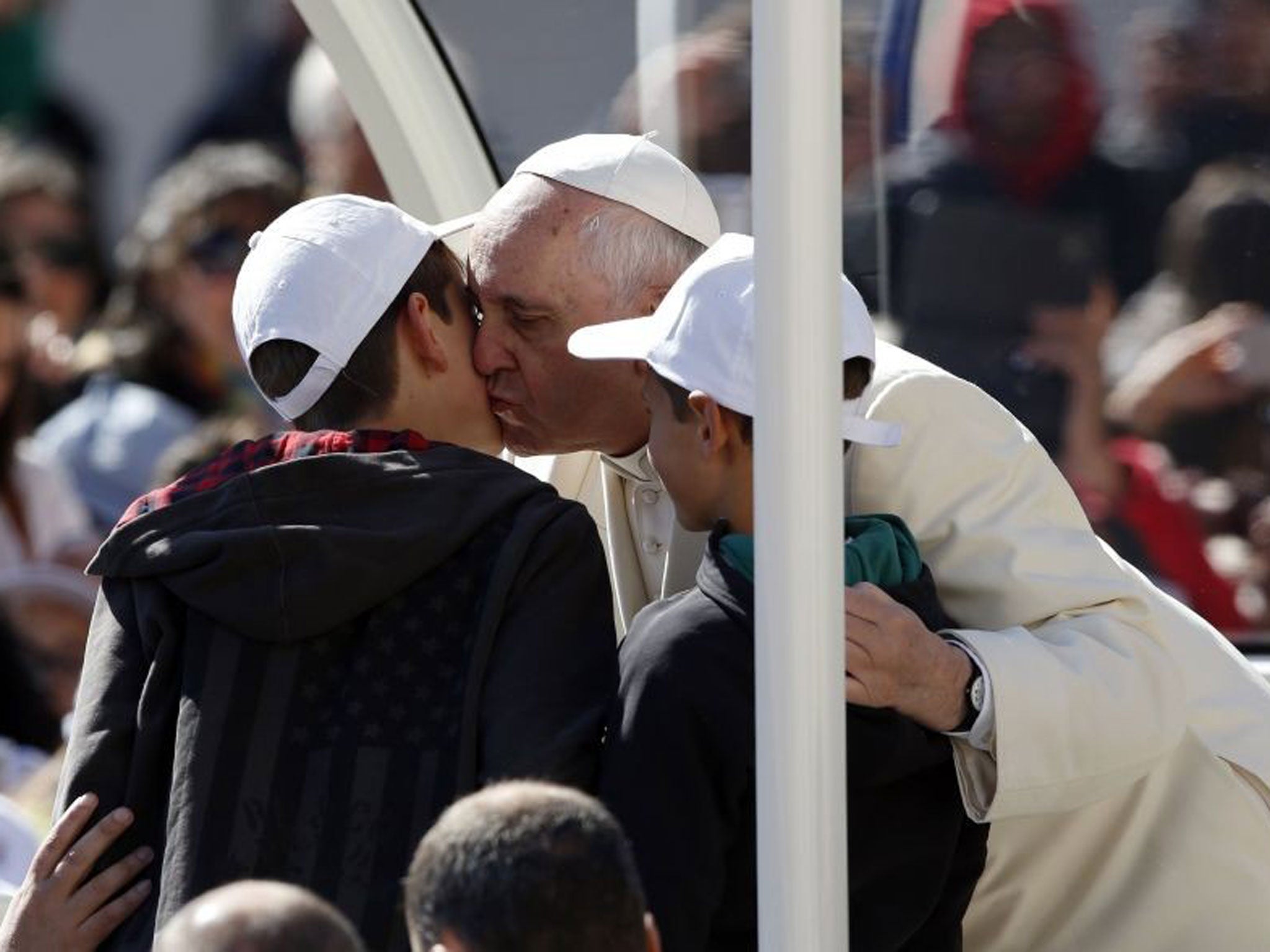 Pope Francis welcomes the Perugian boys onto his Popemobile with a kiss 