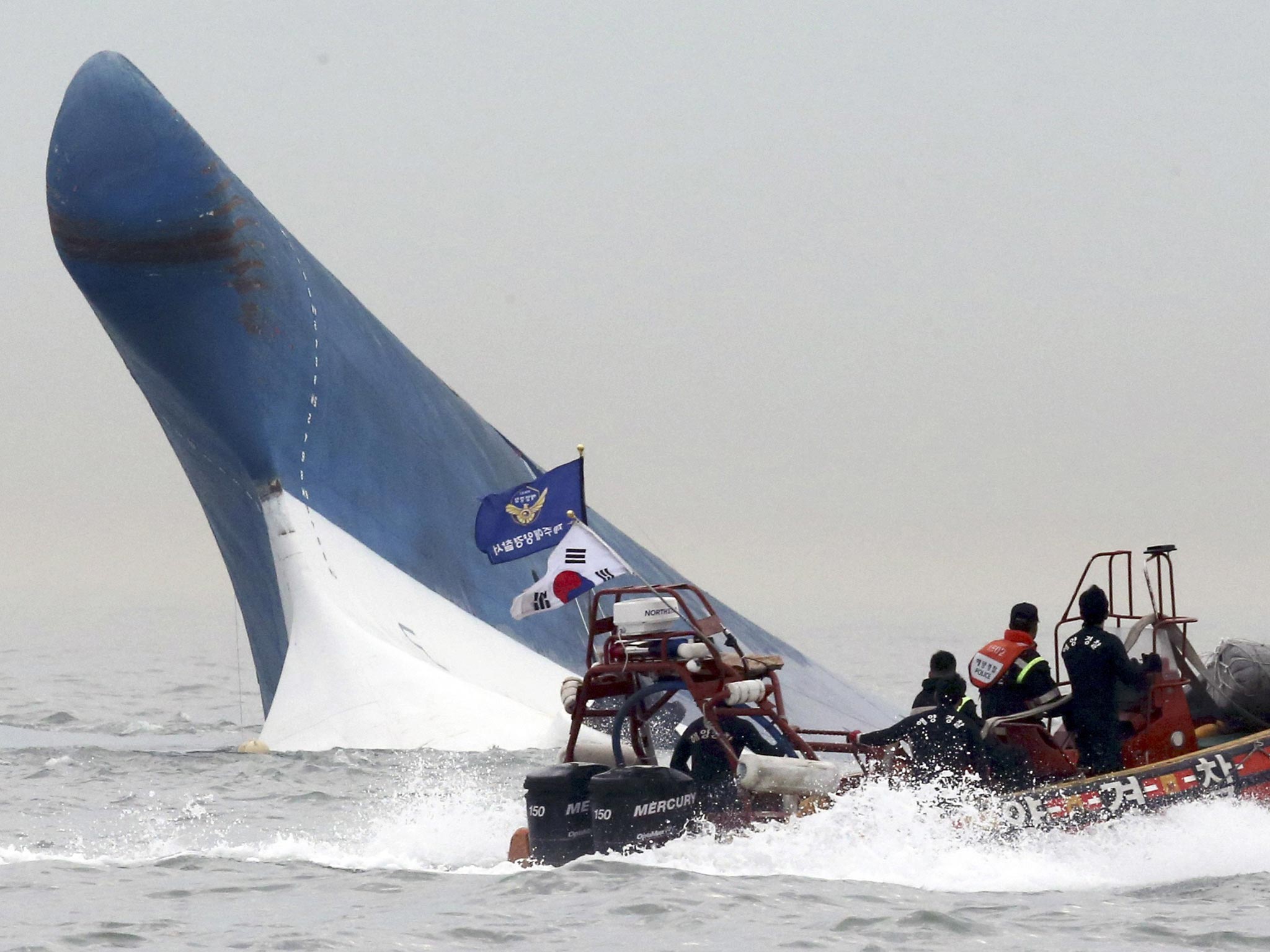 File: South Korean coast guard officers try to rescue passengers from the Sewol ferry as it sinks in the water off the southern coast near Jindo, south of Seoul, South Korea