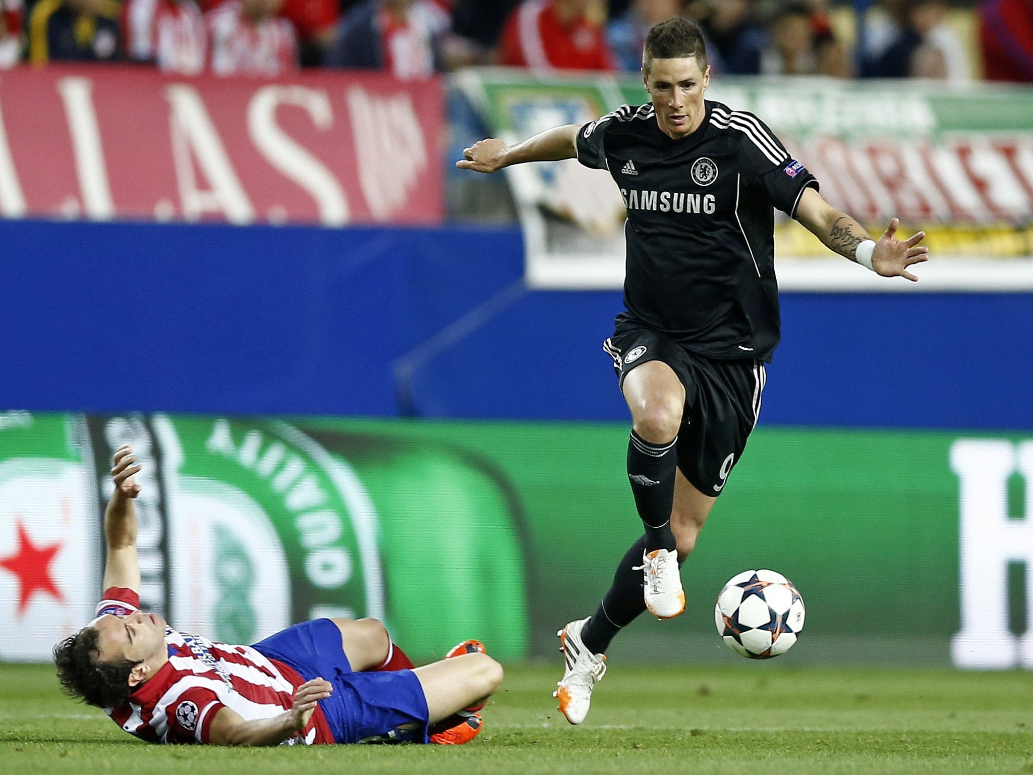 Fernando Torres takes the ball past Diego Godin