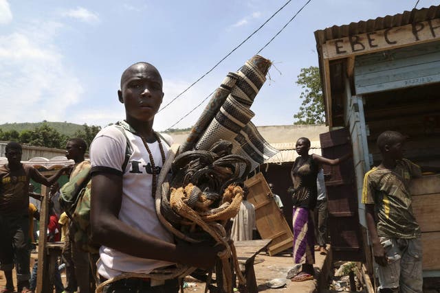 A Christian man carries property left behind by the Muslim community who were evacuated from the PK12 neighbourhood in Bangui. The relocation involves moving Muslims who have sheltered from sectarian violence for months in the PK12 neighbourhood, to the n