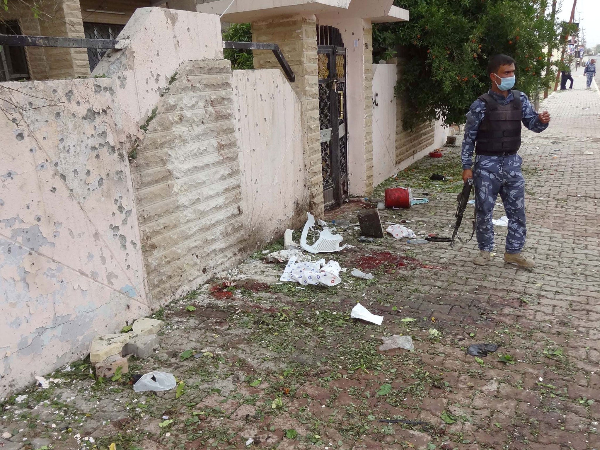 An Iraqi policeman inspects the site of a suicide bombing outside a polling station in the northern Iraqi city of Kirkuk