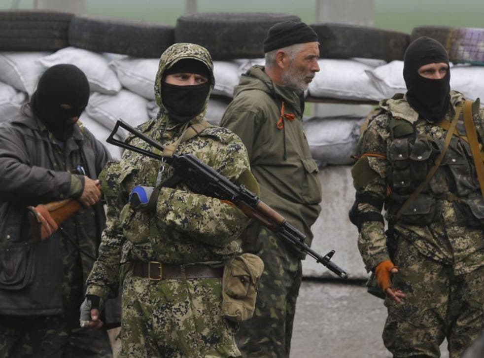 Pro-Russian masked armed militants guard barricades near Slovyansk on Wednesday