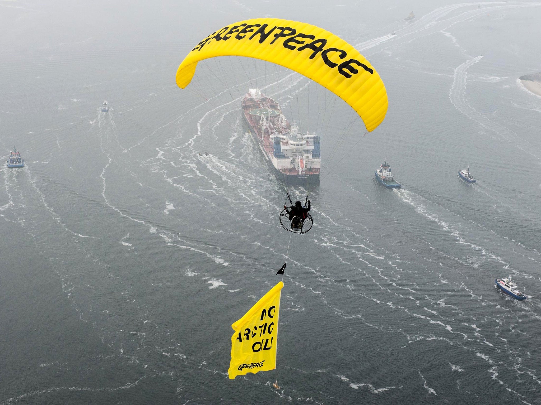 A Greenpeace paraglider flying above the Russian oil tanker Michail Ulyanov with a banner with the words 'No Arctic Oil!' near the harbour of Rotterdam last year