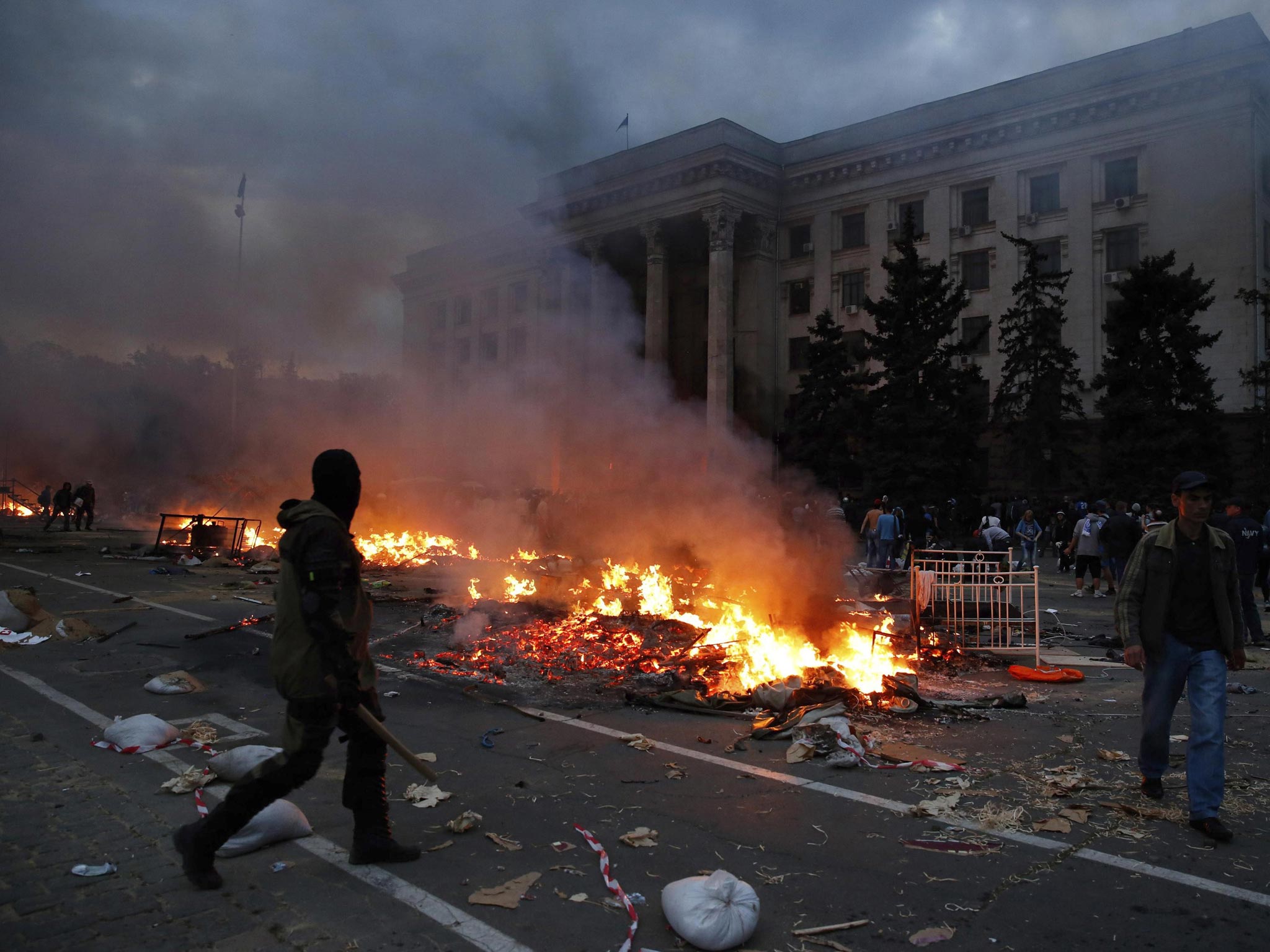 A protester walks past a burning pro-Russian tent camp near the trade union building in Odessa