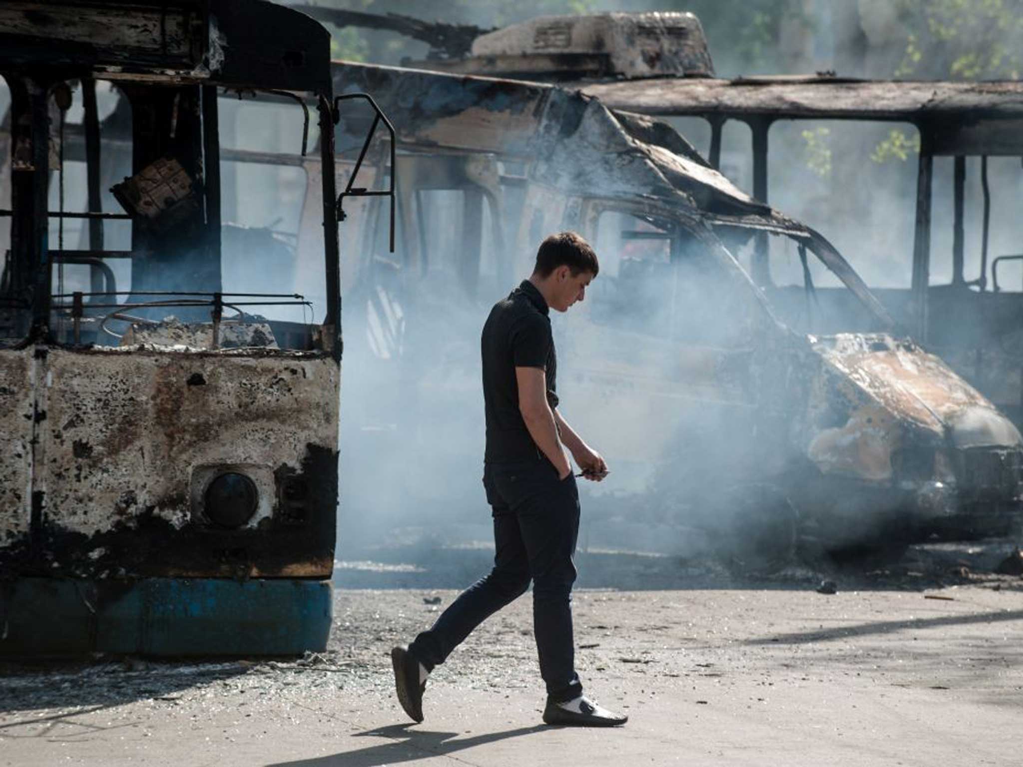Metal and flesh: A man walks past a charred van and bus in Kramatorsk yesterday