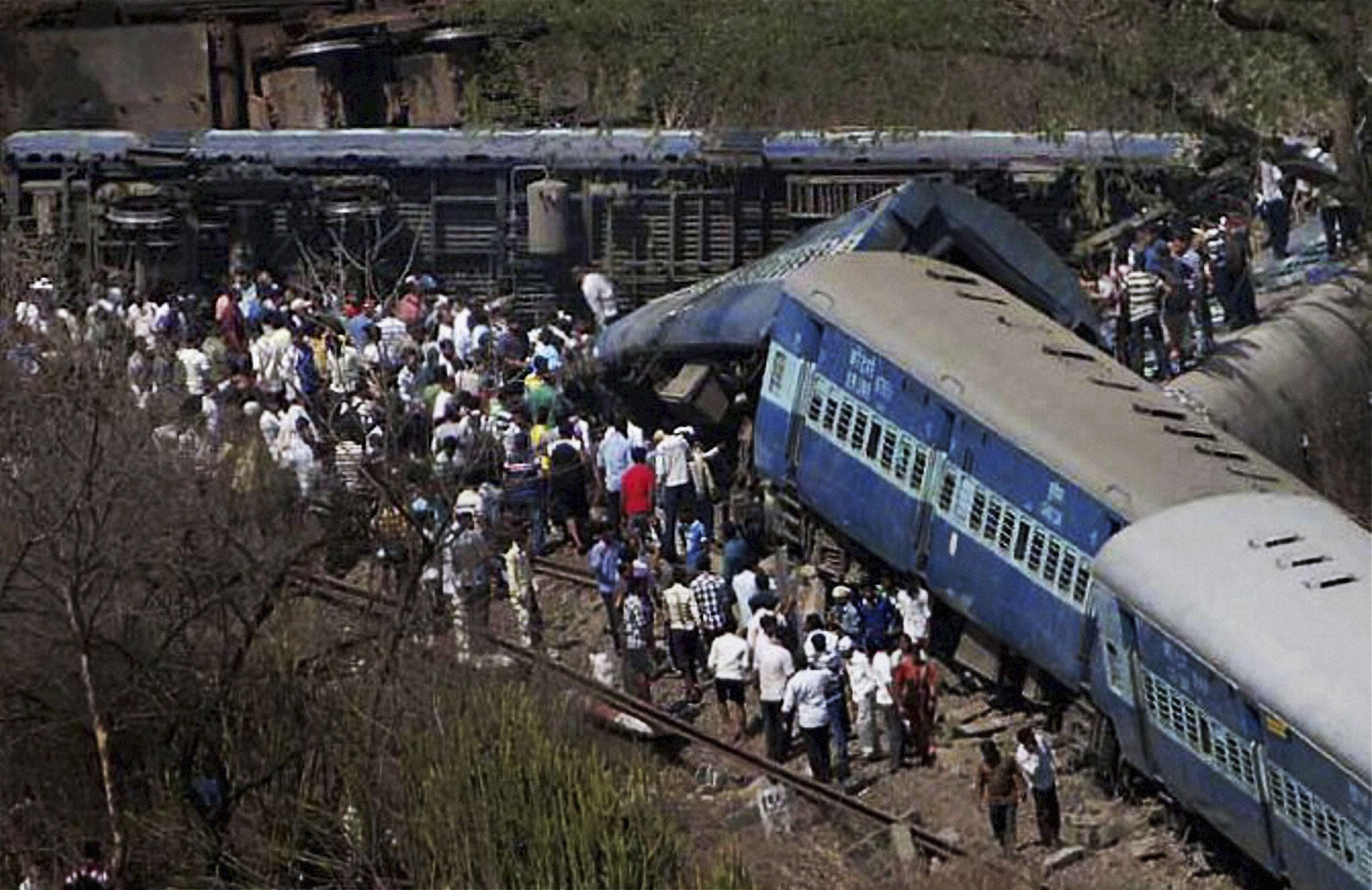 People gather around the train; the cause of the accident was not immediately known