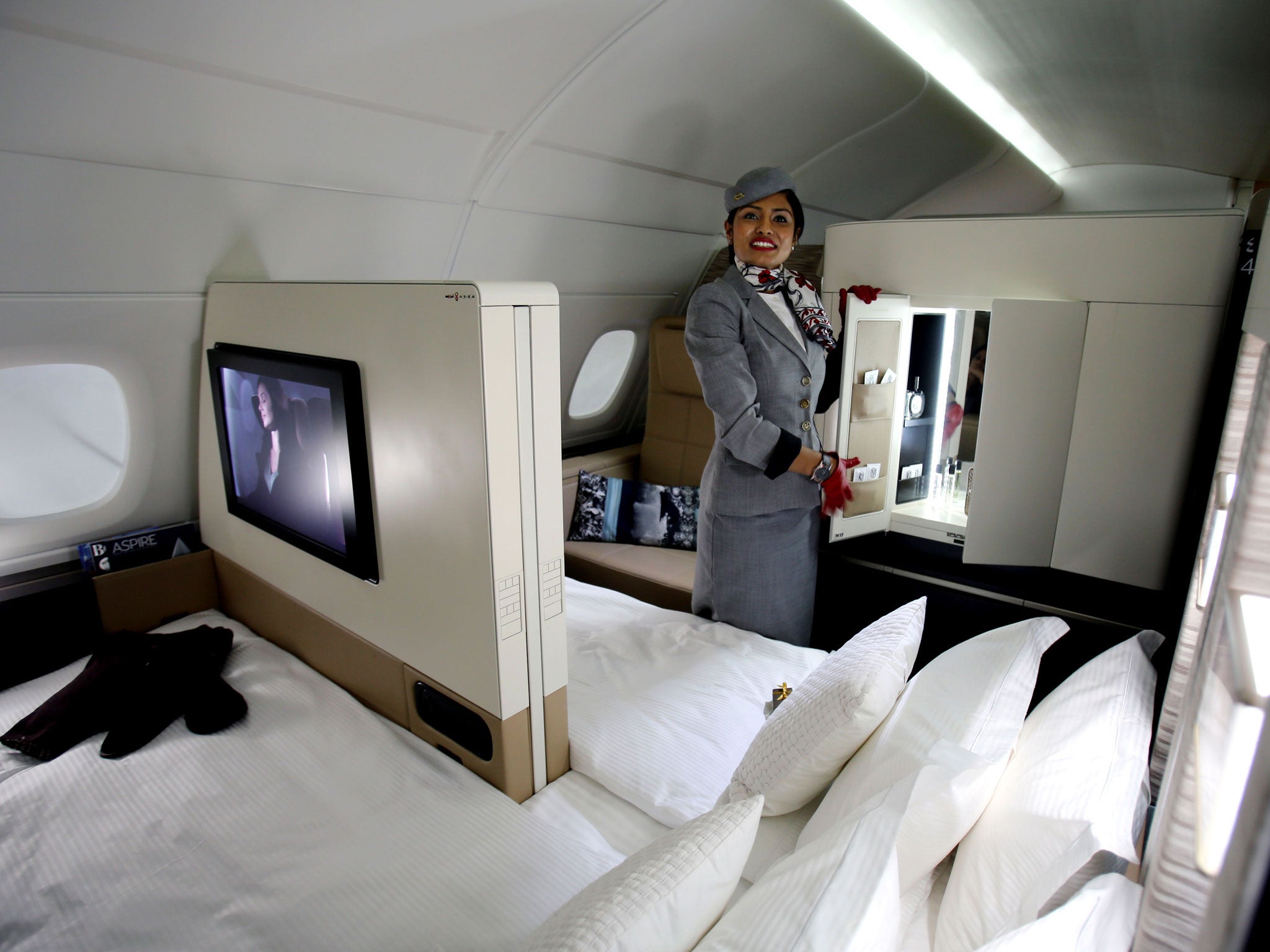 An Etihad Airways official stands inside a mock-up first class cabin,