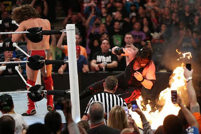 Kane falls towards a flaming table in the main event against Daniel Bryan at WWE Extreme Rules