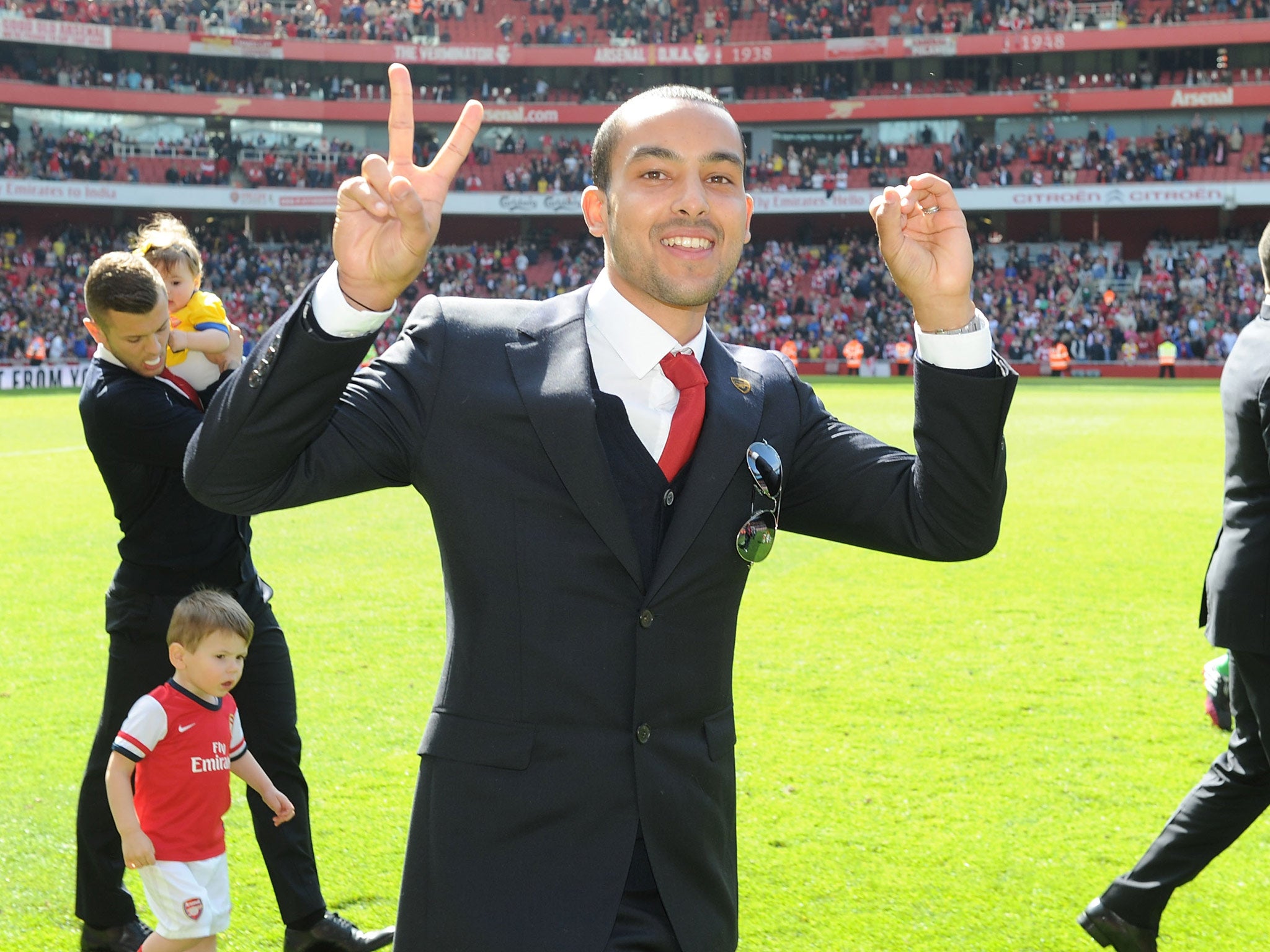 Theo Walcott makes a 2-0 gesture as Arsenal parade around the Emirates after their final home game of the season