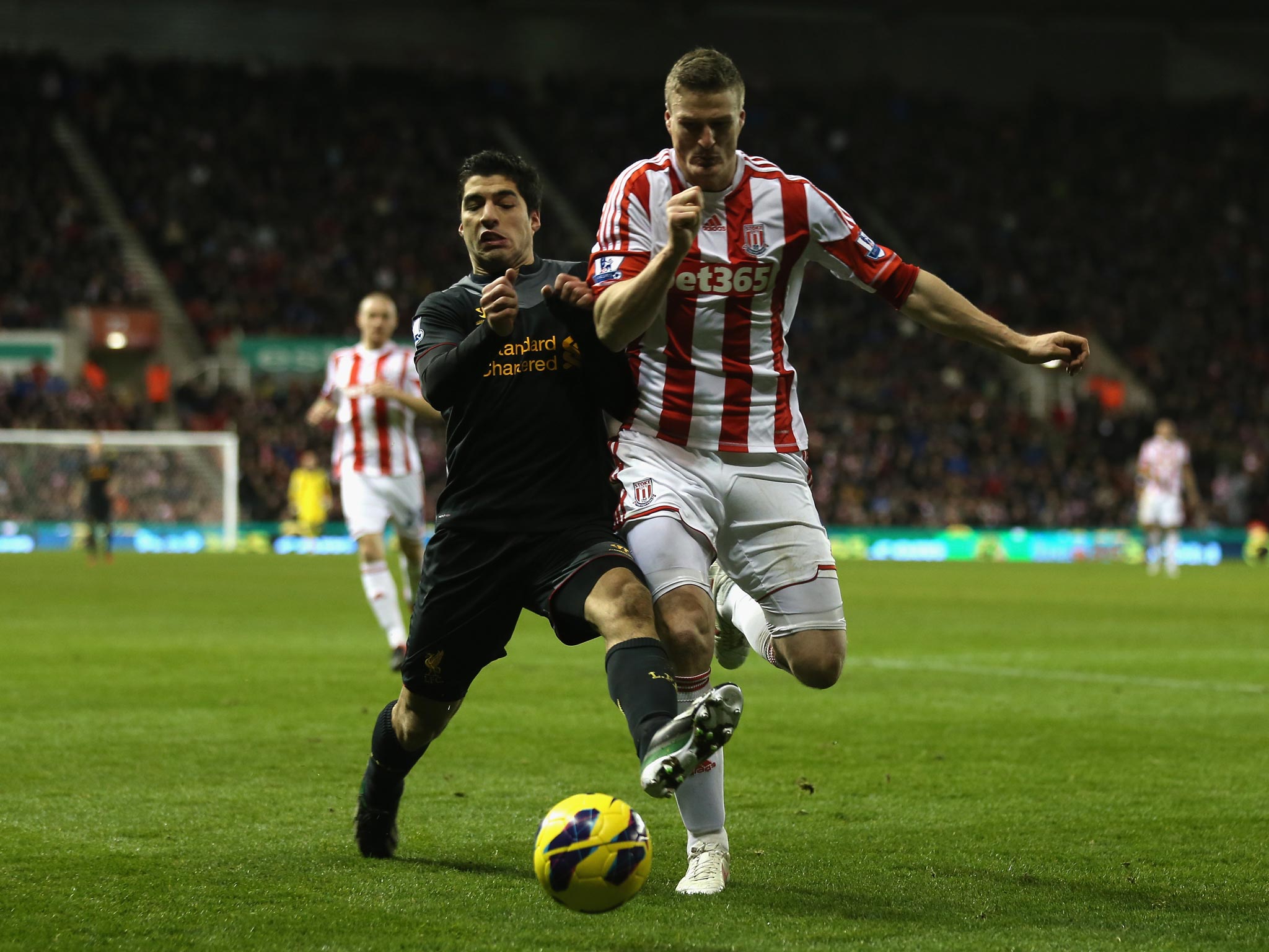 Luis Suarez and Robert Huth battle for the ball during Stoke v Liverpool