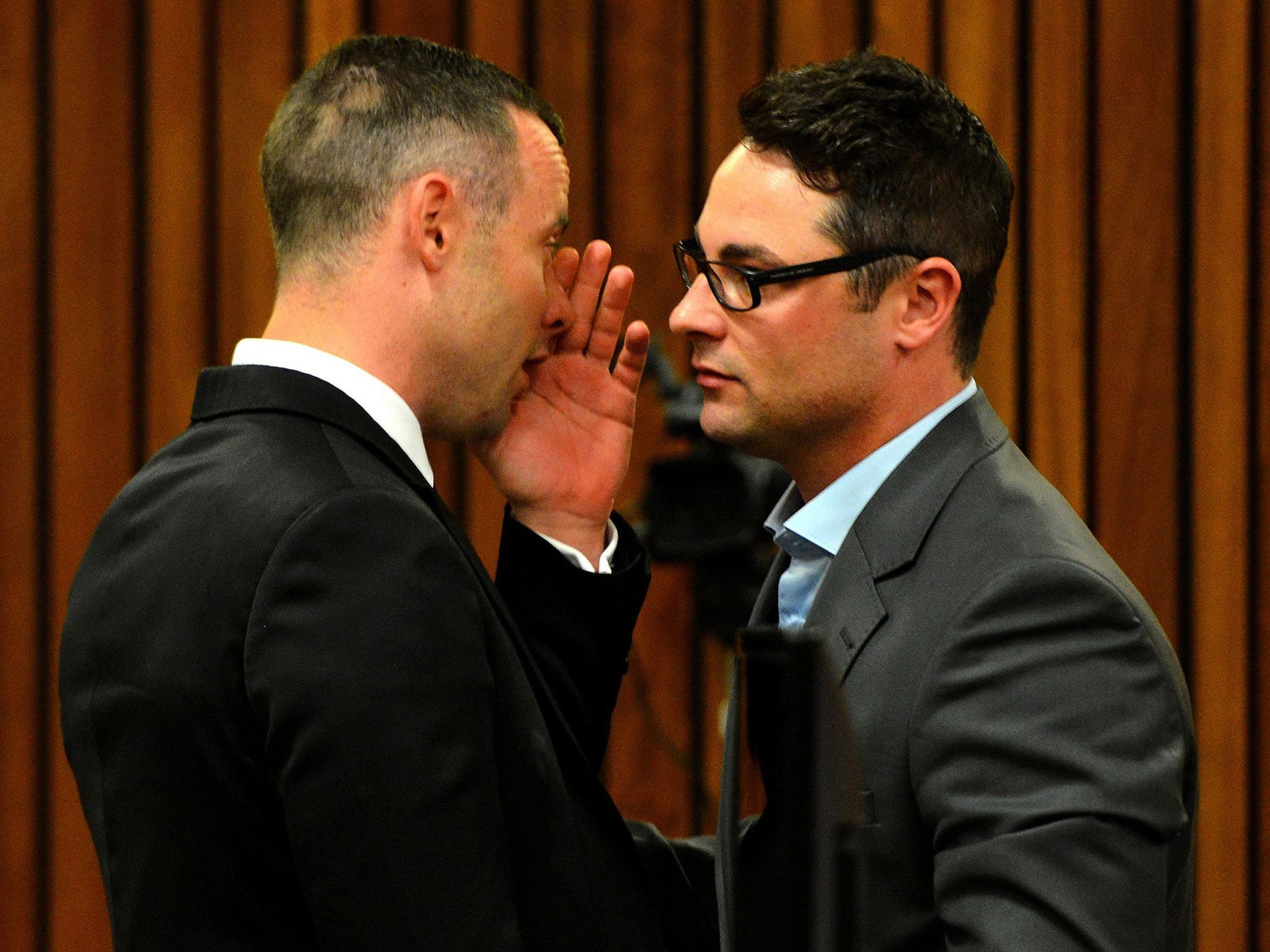 Oscar Pistorius talks with his brother Carl at the high court in Pretoria