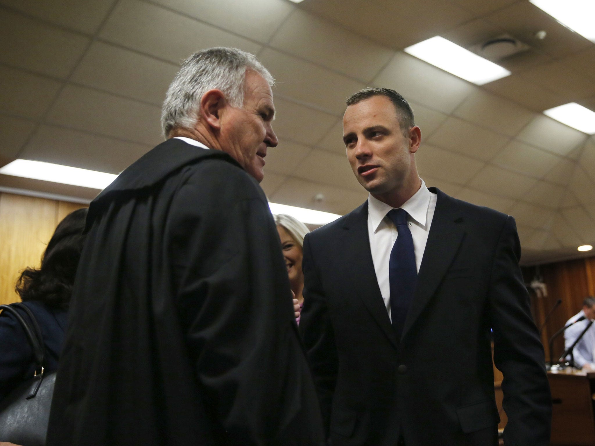Oscar Pistorius speaks with his defence lawyer Barry Roux at the North Gauteng High Court in Pretoria prior to a hearing of his murder trial