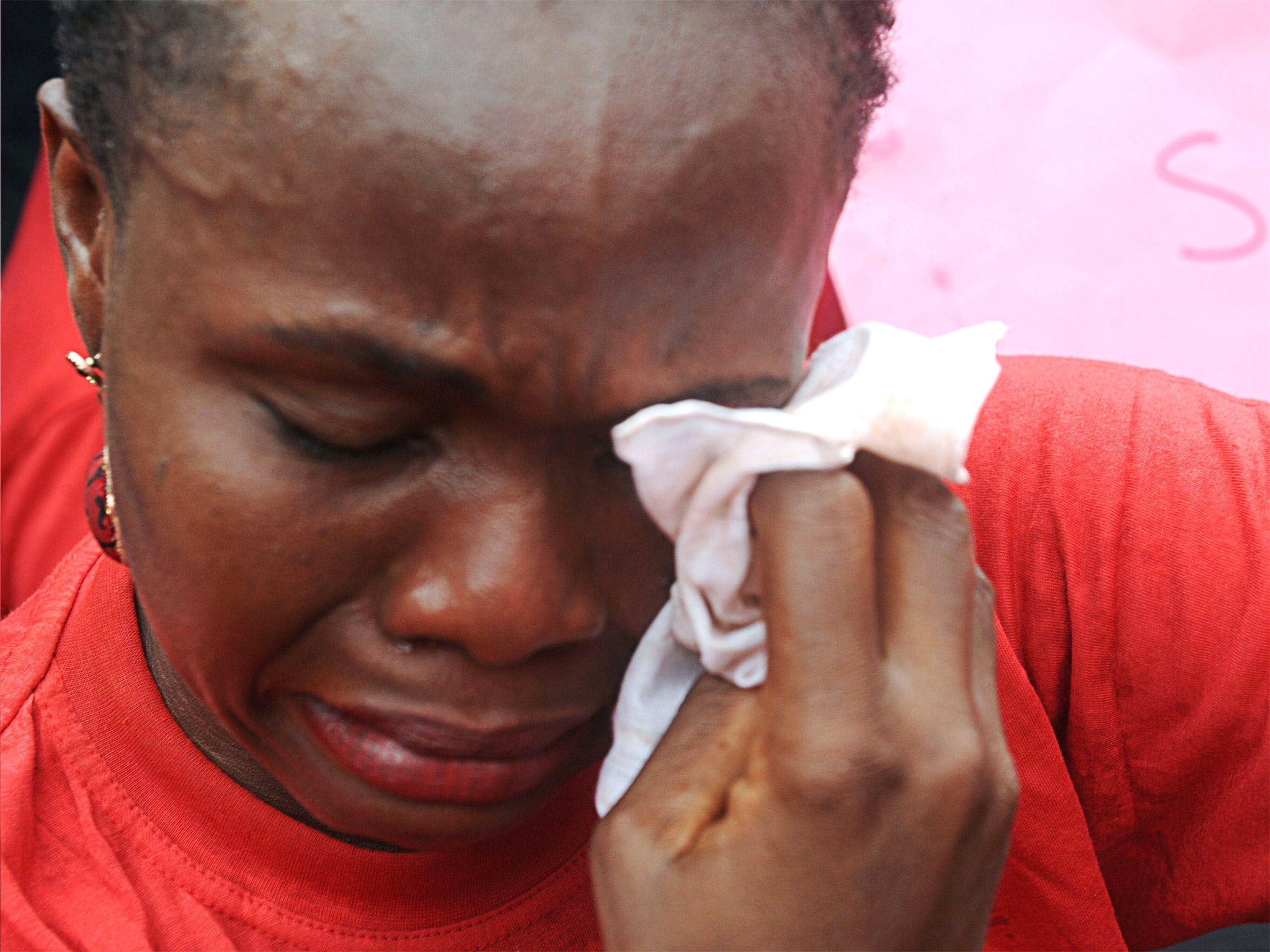 One of the mothers of the missing Chibok school girls wipes her tears at a rally in Abuja