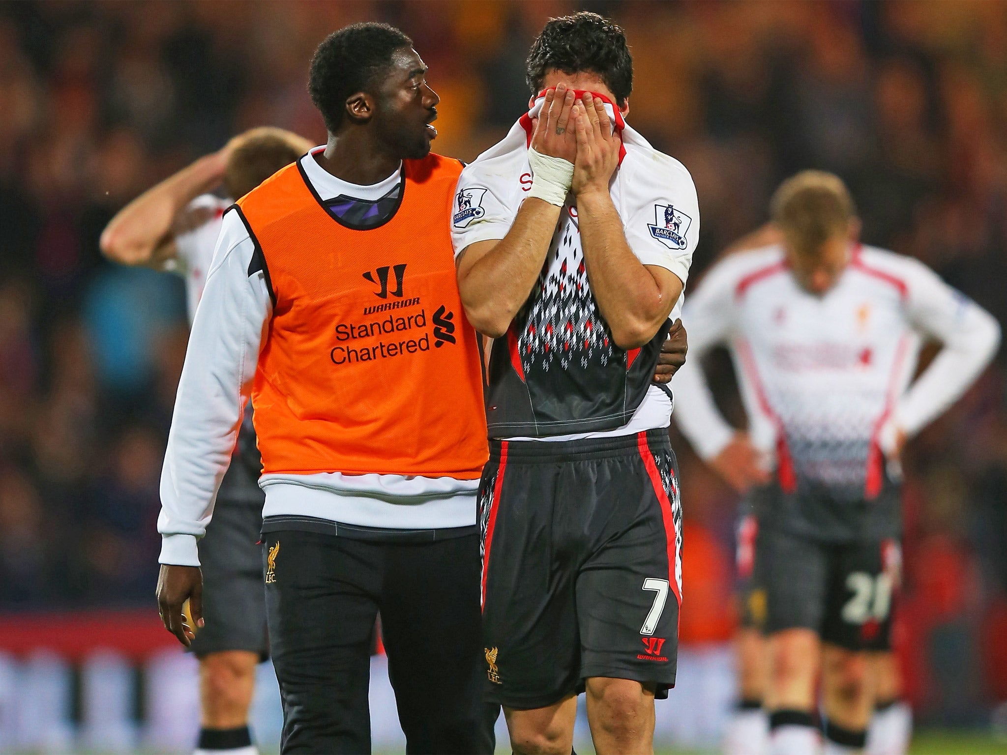 Luis Suarez is consoled by Kolo Touré after Liverpool all but threw away the title on Monday
