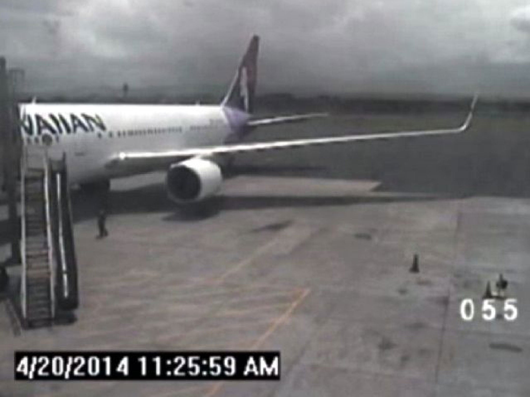 This April 20, 2014 image taken from a surveillance video provided by the Hawaii Department of Transportation, shows a California teen, left, after hopping from a jet's wheel well in Maui, Hawaii. Police said Tuesday, May 6, that they plan to interview th