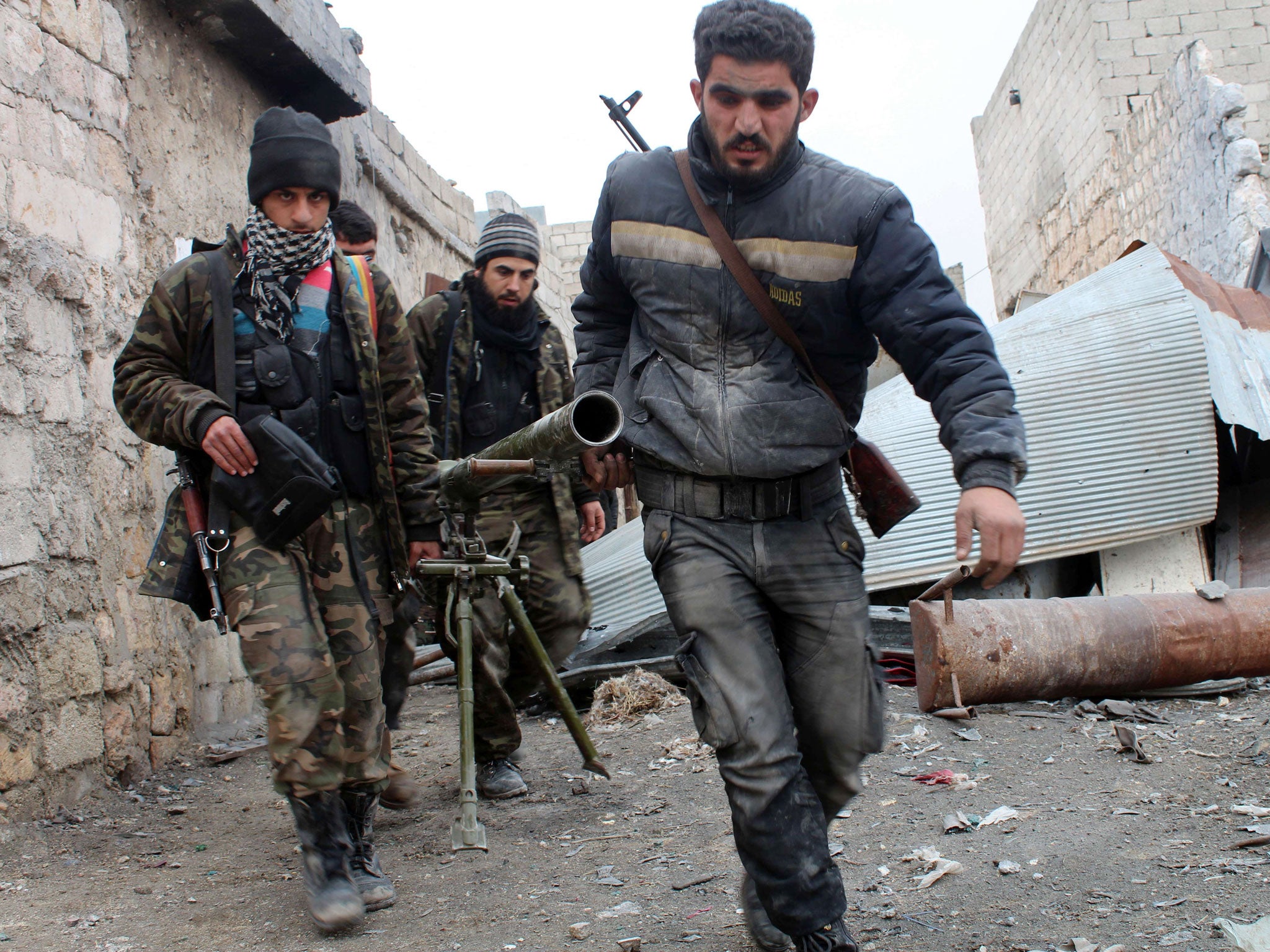 Opposition fighters carrying a rocket launcher during clashes against government forces in the Sheikh Lutfi area, west of the airport in the northern Syrian city of Aleppo