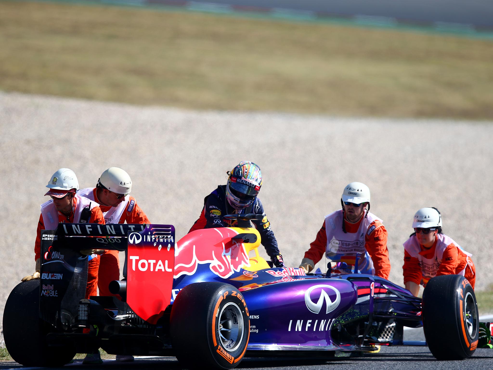 Sebastian Vettel pushes his Red Bull after it grinds to a halt on the Catalunya track