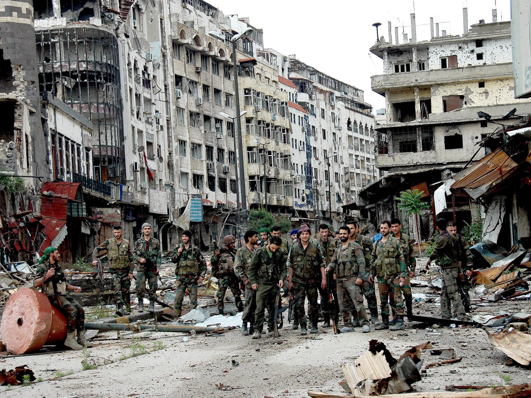 Syrian army forces stand on a street at the entrance of Hamidiya market in the old city of Homs