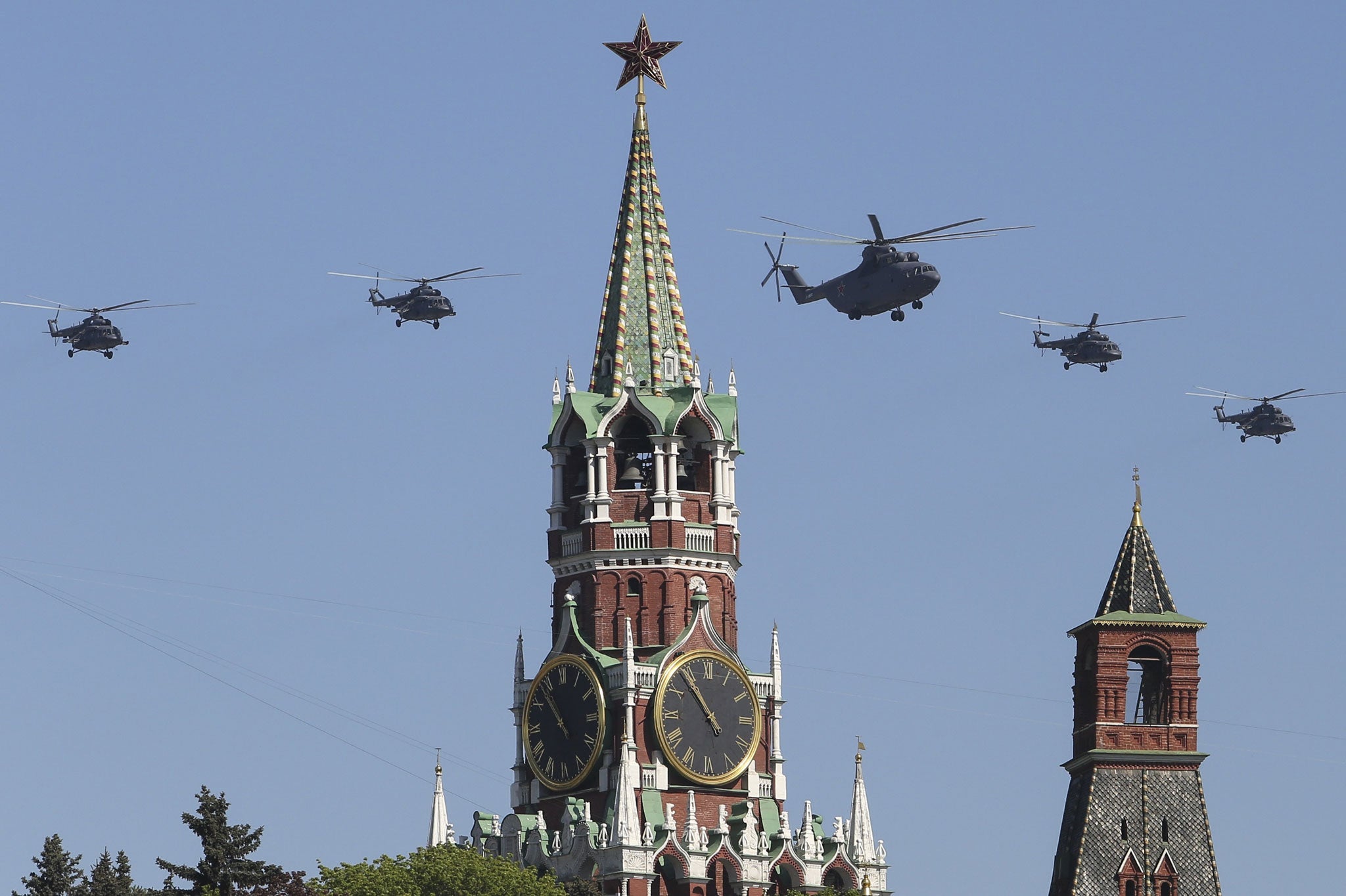 Russian Air Force helicopter Mi-26, center, with Mi-8, flies over Red Square during a Victory Day parade in Moscow