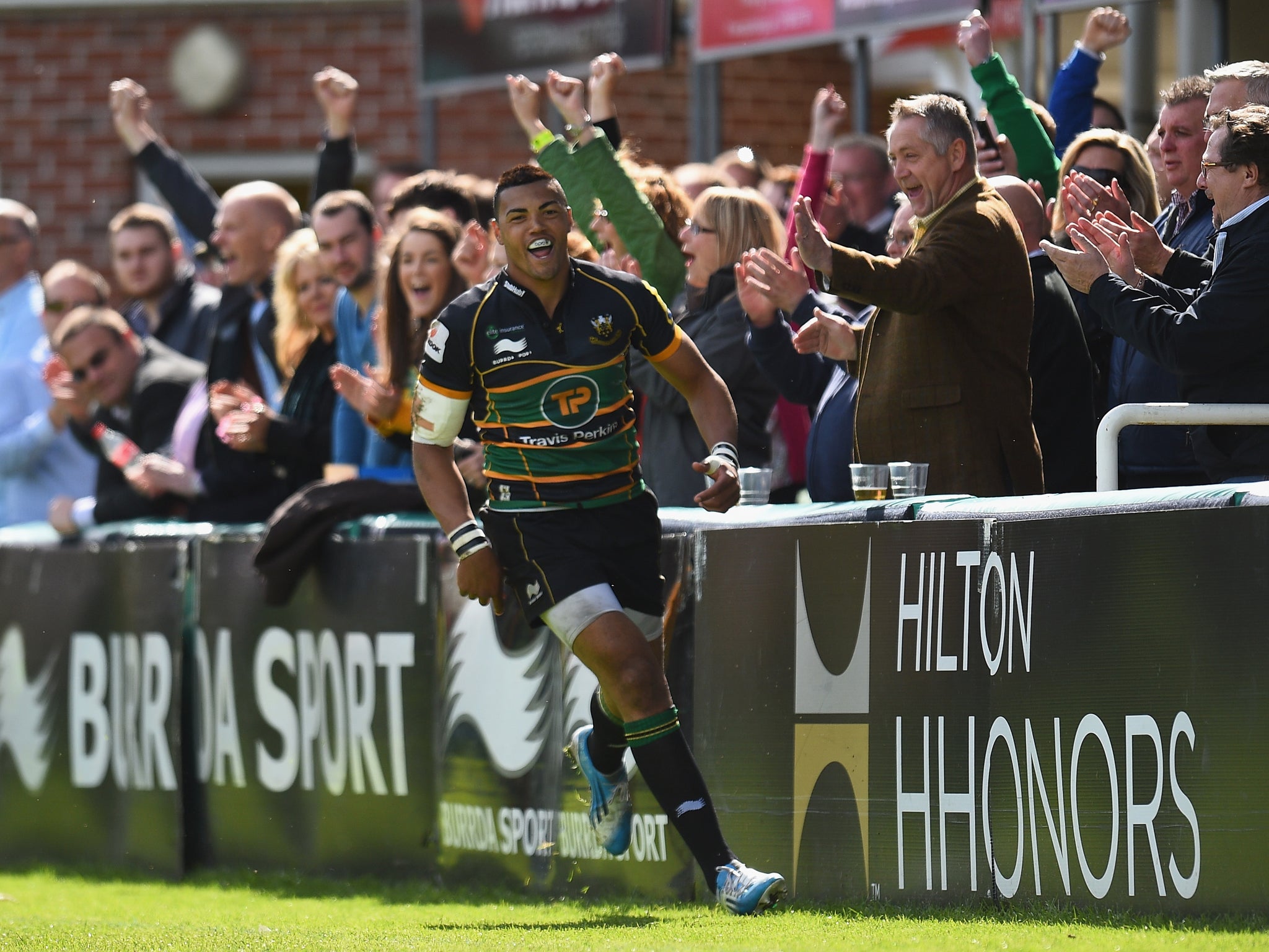 Luther Burrell celebrates scoring a try in front of the celebrating Northampton fans