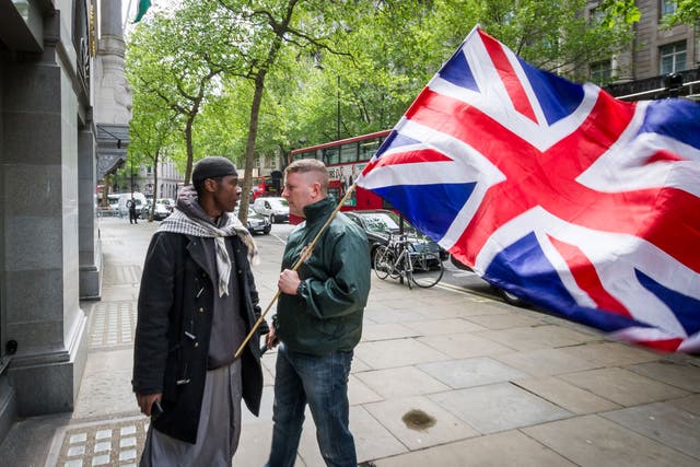 Paul Golding, right, leader of the patriot group 'Britain First', confronts an Islamist outside the High Commission of India in London