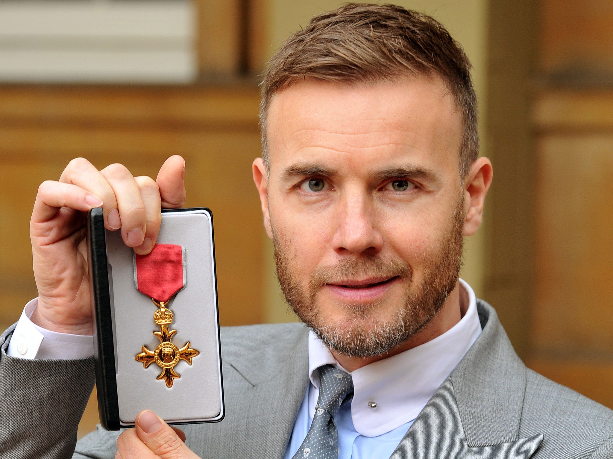 Gary Barlow holding his OBE, as the Take That star faced calls to hand back his OBE over claims he invested in a tax avoidance scheme. PRESS ASSOCIATION Photo. Issue date: Monday May 12, 2014. Prime Minister David Cameron hit out at "aggressive" tax avoid