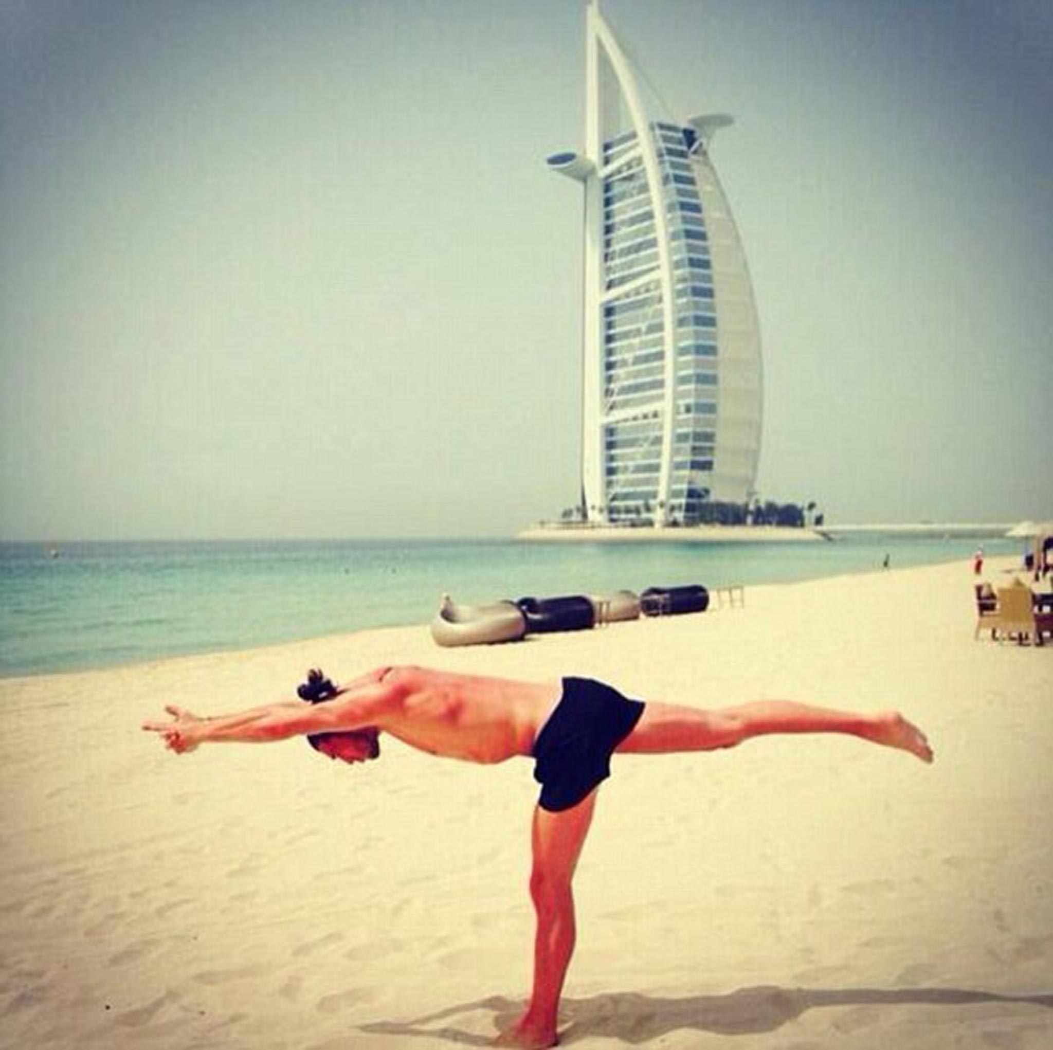 Andy Carroll practicing yoga on the beach in Dubai