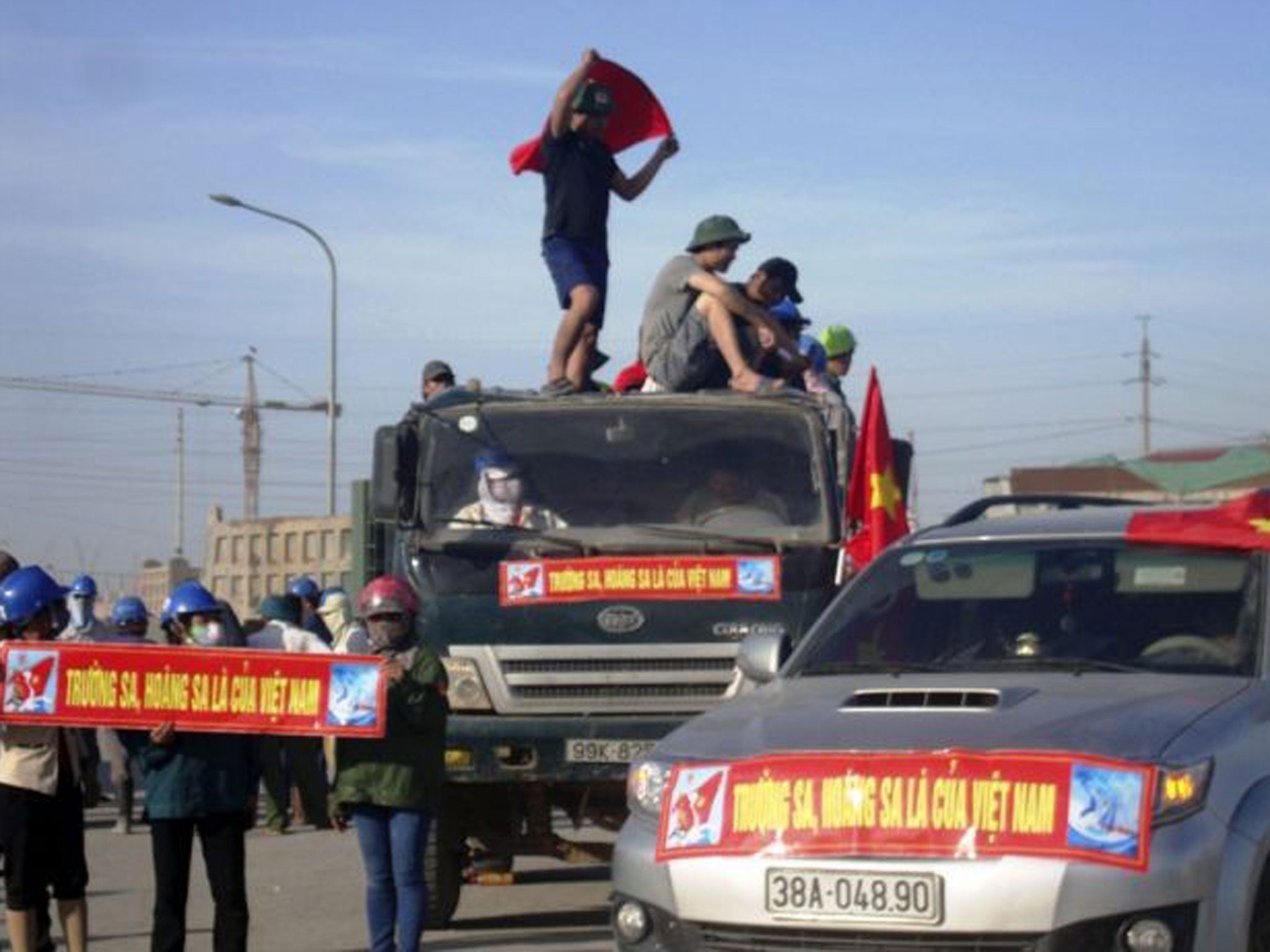 Workers near Formosa factory hold banners reading 'Paracel Islands and Spratly Islands belong to Vietnam'