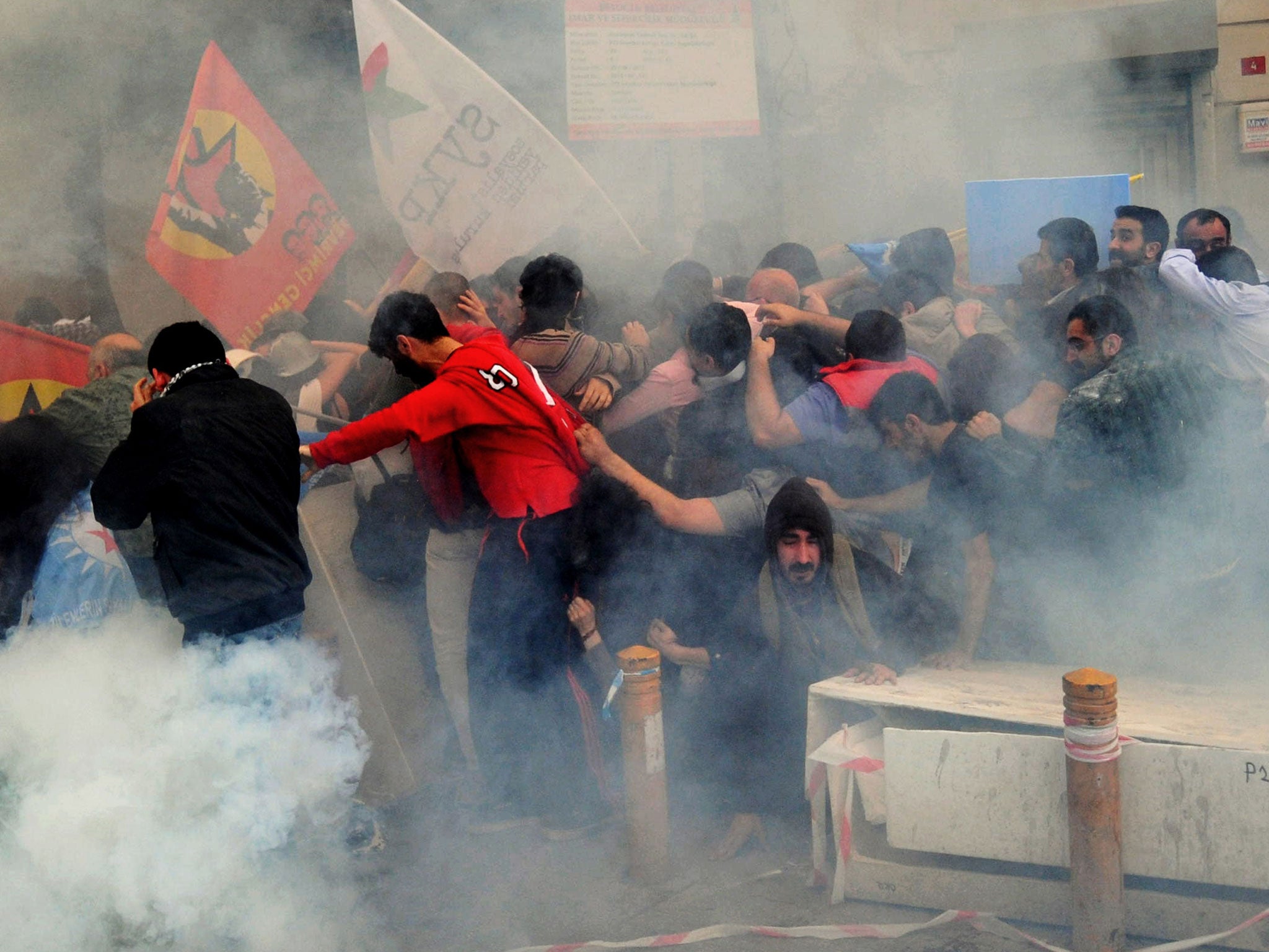 Protesters run away from tear gas during a protest on Istiklal avenue in Istanbul
