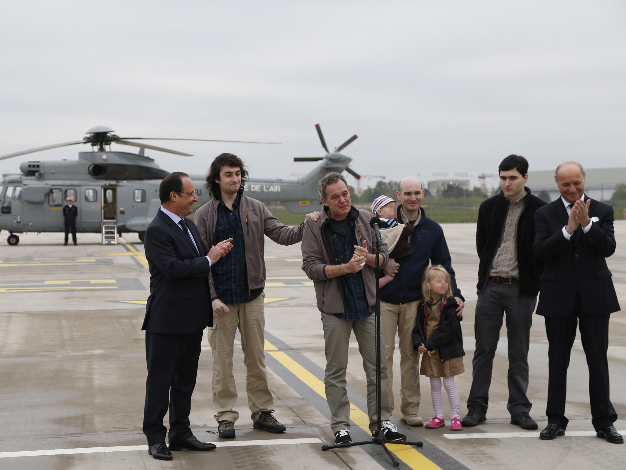 Safe return: French President Francois Hollande (left) greets the freed French journalists as they arrive back in France