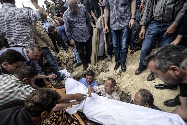 People hold the body of one of the 282 confirmed
dead miners at a funeral yesterday in Soma