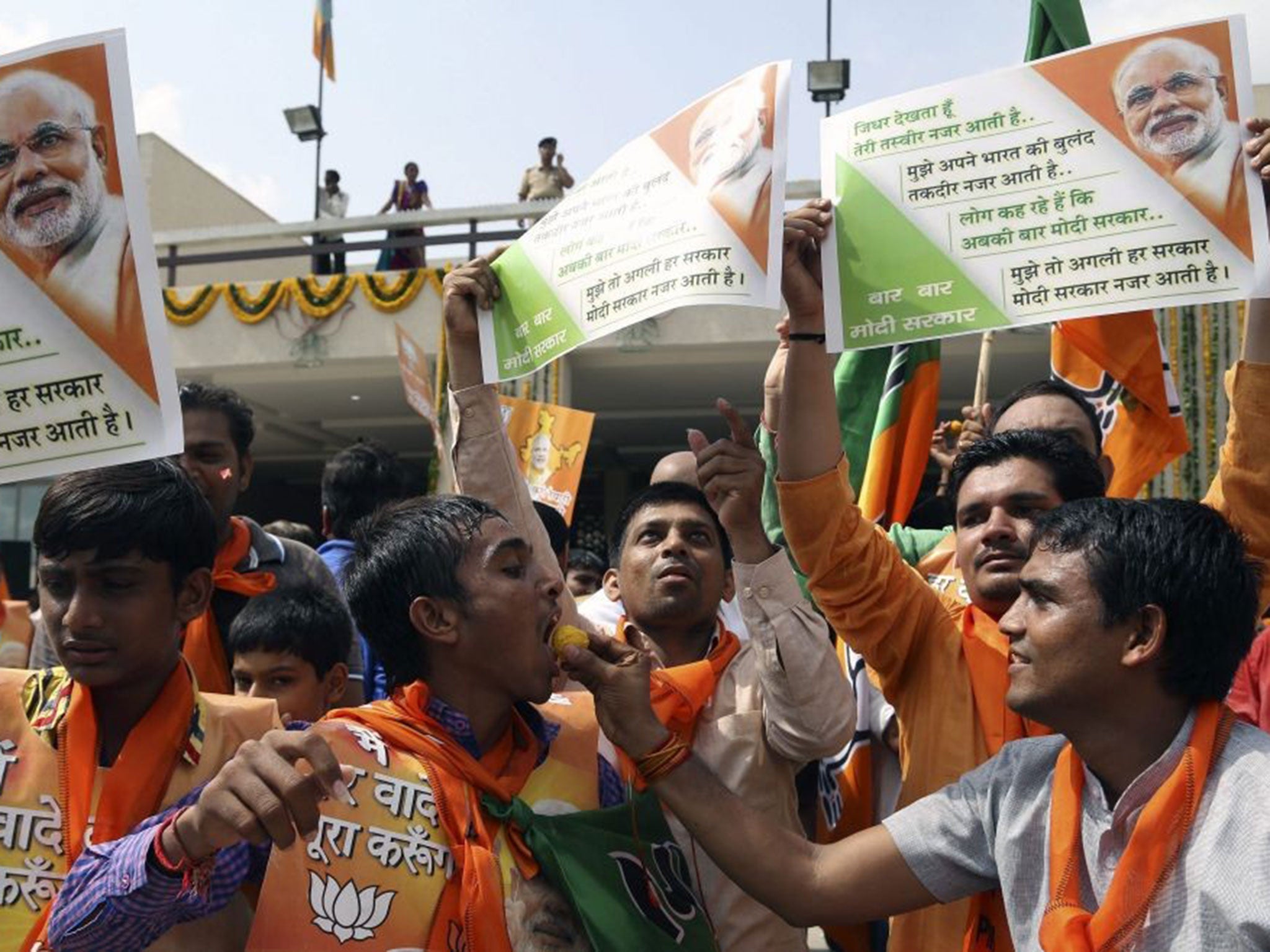 Supporters of Narendra Modi celebrate by dancing and distributing sweets at the BJP state headquarters in Gandhinagar, the capital of Gujarat