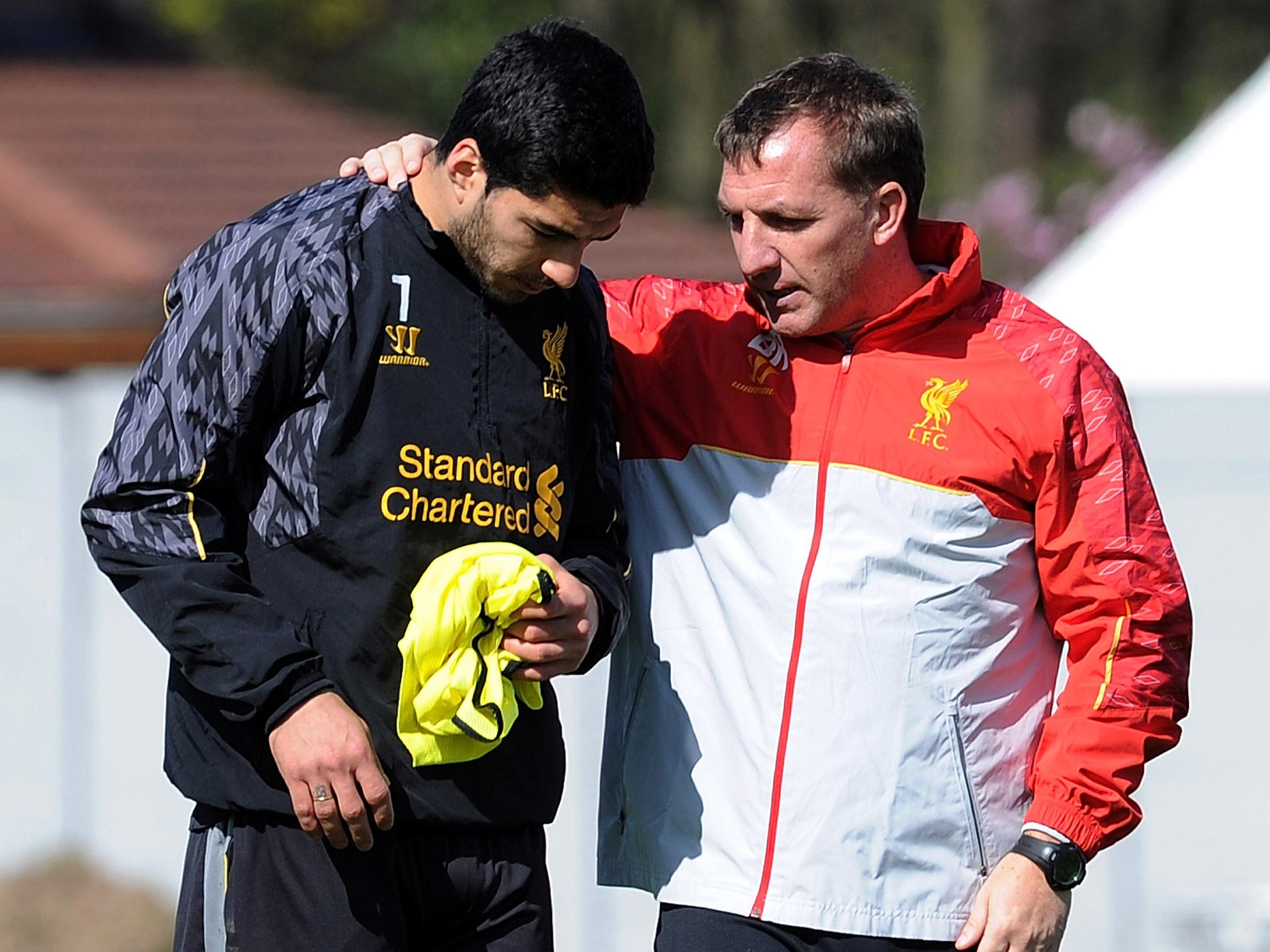 Brendan Rodgers talks with Luis Suarez during a Liverpool training session
