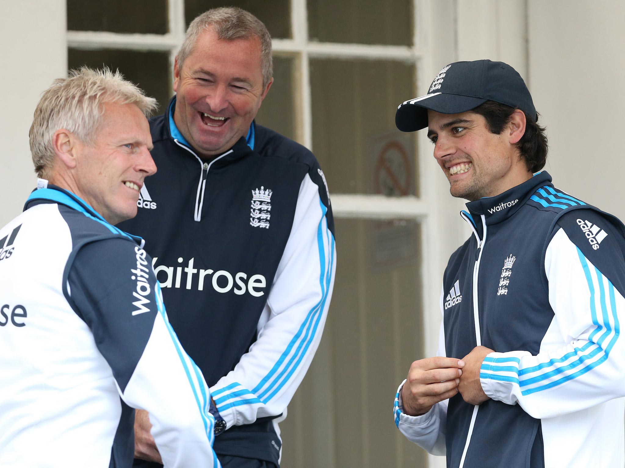 England coaches Peter Moores (L) and Paul Farbrace (C) stand with England captain Alastair Cook as they wait for conditions to improve during the One Day International against Scotland