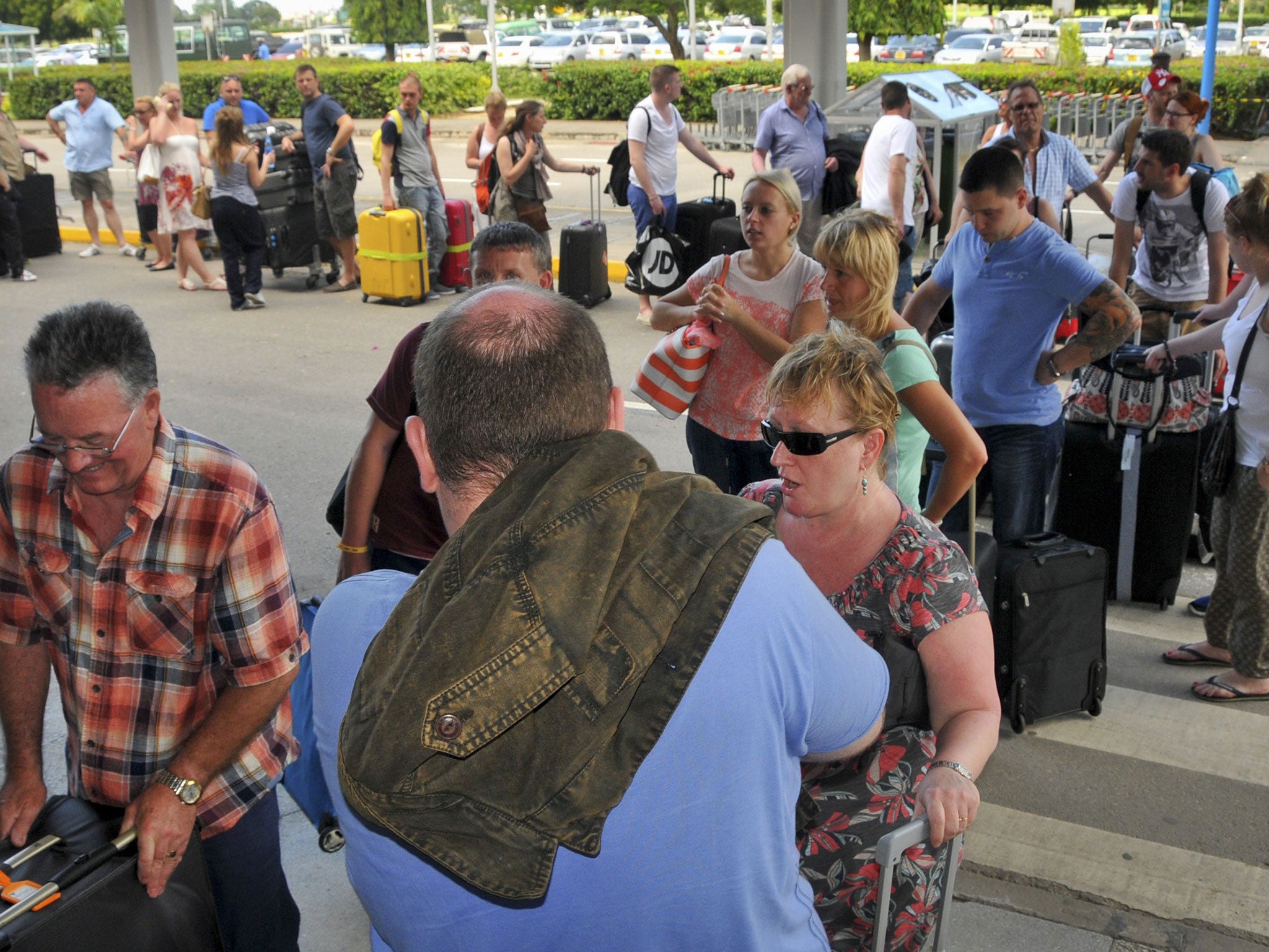 British tourists queue with their luggage to leave by charter flight from the international airport in Mombasa, Kenya