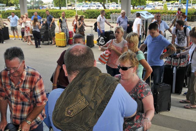 British tourists queue with their luggage to leave by charter flight from the international airport in Mombasa, Kenya