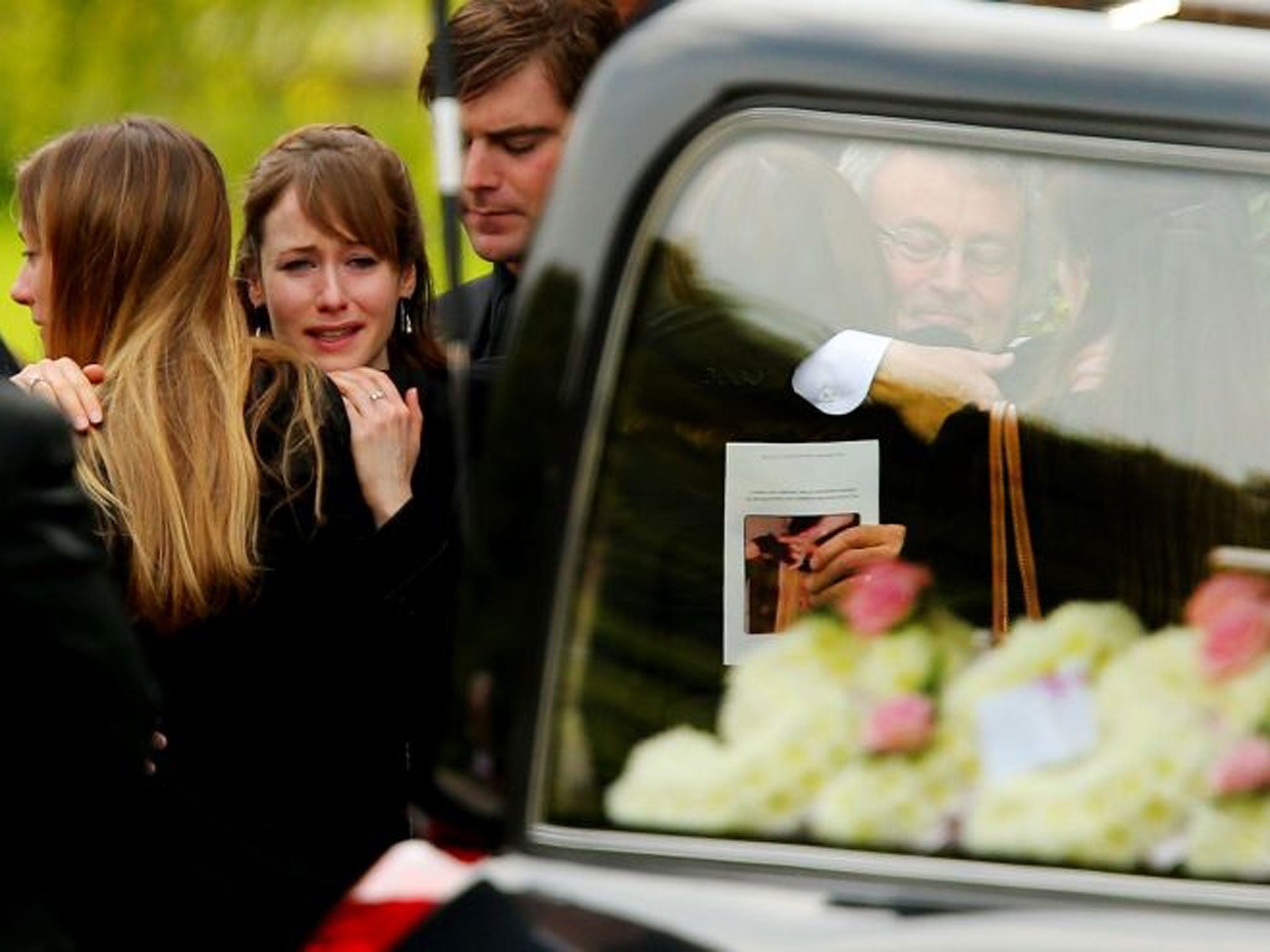 Emma Maguire, second left, and her father Don, right, hug well-wishers following the funeral of Ann Maguire (Getty Images)