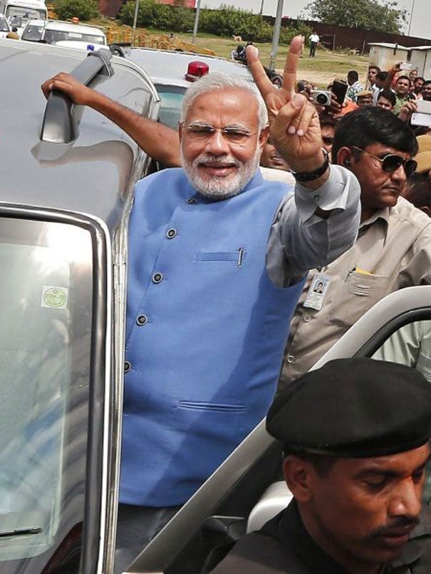 Hindu nationalist Narendra Modi, the prime ministerial candidate for India's Bharatiya Janata Party (BJP), gestures towards his supporters from his car during a road show upon his arrival at the airport in New Delhi May 17