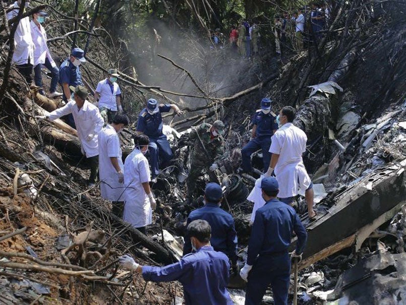 Rescue workers search an air force plane crash site near Nadee village,