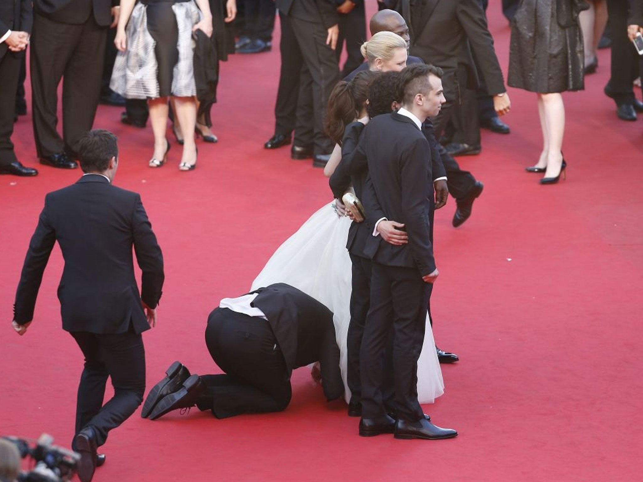Photographers caught the moment the prankster crawled under Ferrera's gown