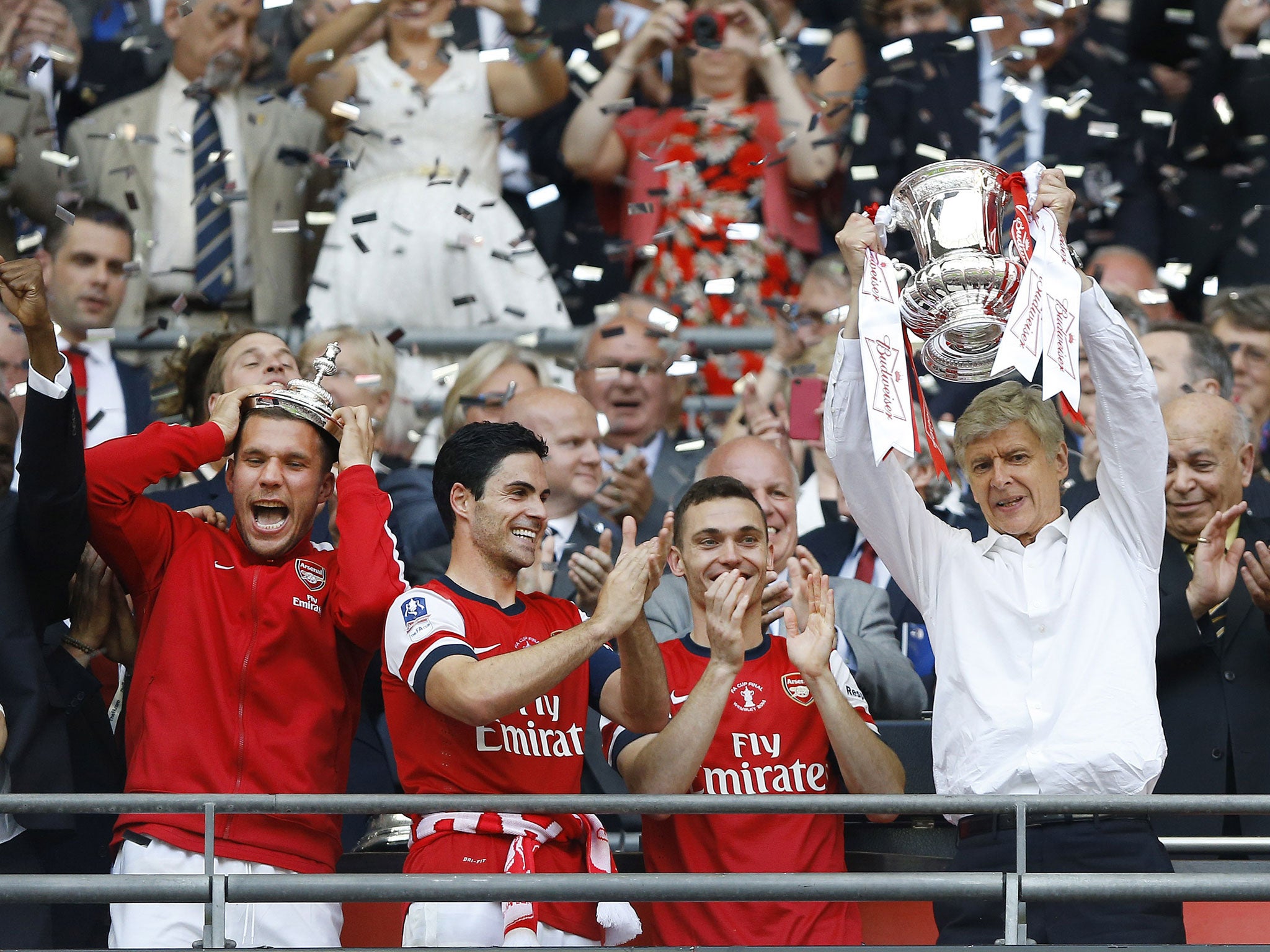 Back in the old routine: Arsène Wenger, the Arsenal manager, still remembers what to do with a trophy as he lifts the 2014 FA Cup after a thrilling 3-2 comeback victory over Hull City in the final