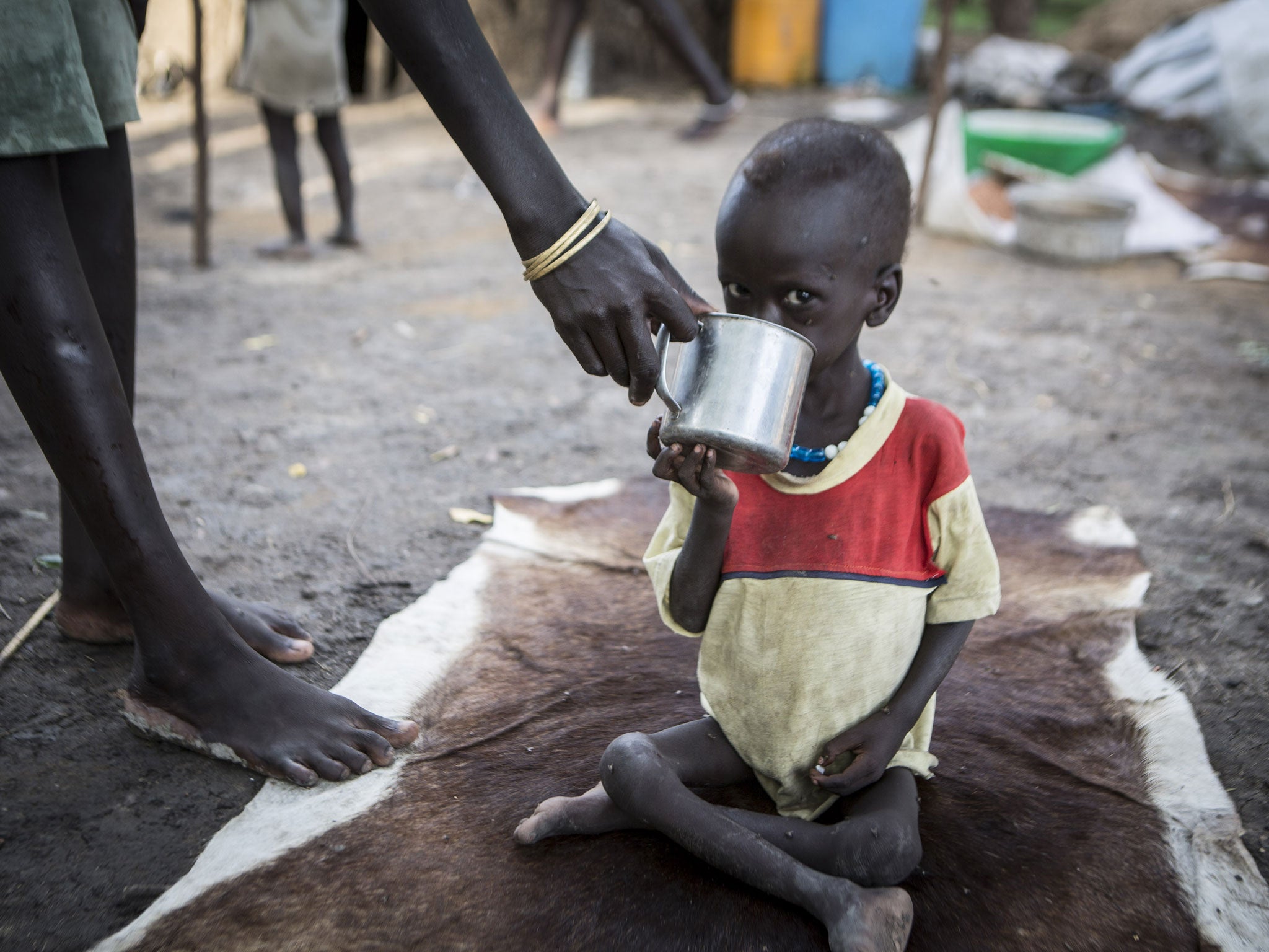 Nhial, 3, being given water by his mother. He is receiving treatment at the Akobo Save the Children feeding clinic in South Sudan.