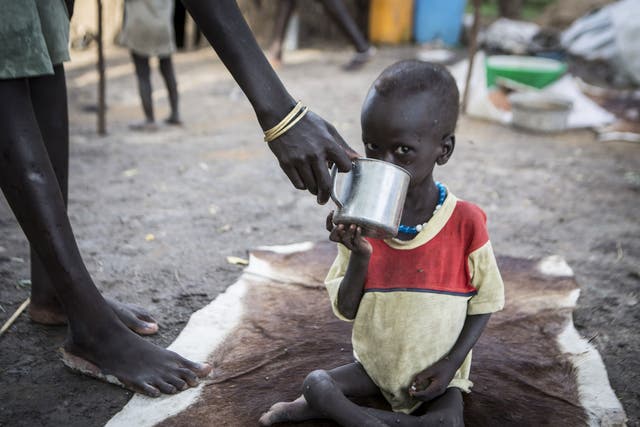 Nhial, 3, being given water by his mother. He is receiving treatment at the Akobo Save the Children feeding clinic in South Sudan. 