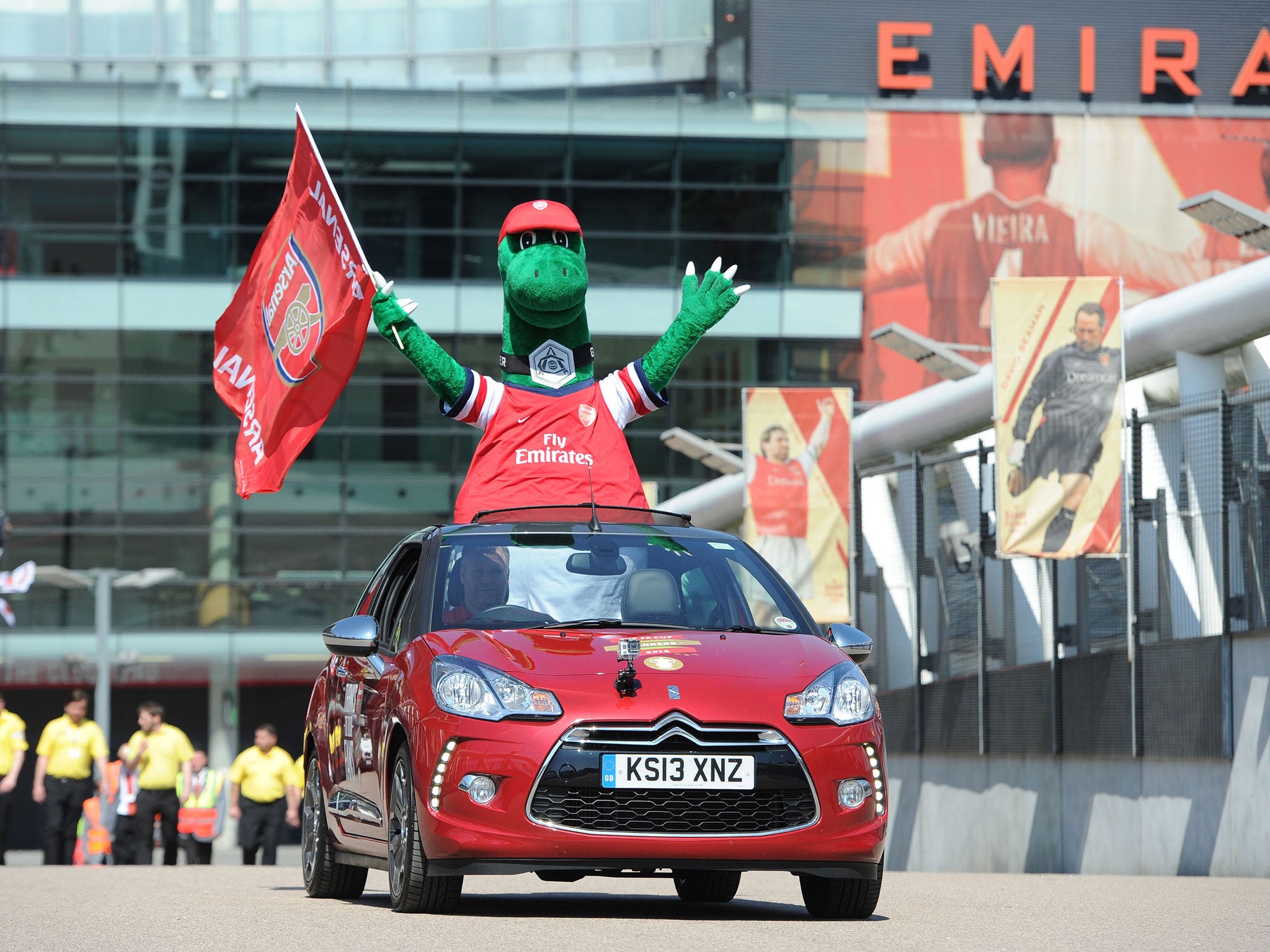 Arsenal mascot Gunnersaurus Rex waves as the team parade with the FA Cup trophy