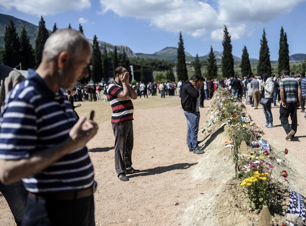 Relatives mourn at the cemetery where some of those killed in the Soma mine explosion are being buried